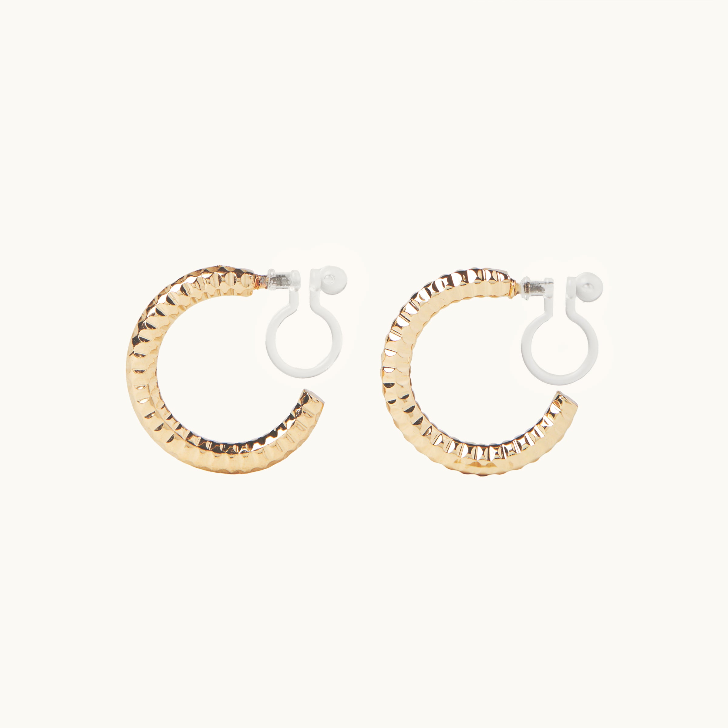 Image of the Ribbed Hoop Clip On Earrings in Gold. Made with a Resin Clip-On closure, these earrings provide a secure hold for 8-12 hours and are suitable for all ear sizes and types. Elevate your look with these versatile and long-lasting earrings. Set includes one pair.