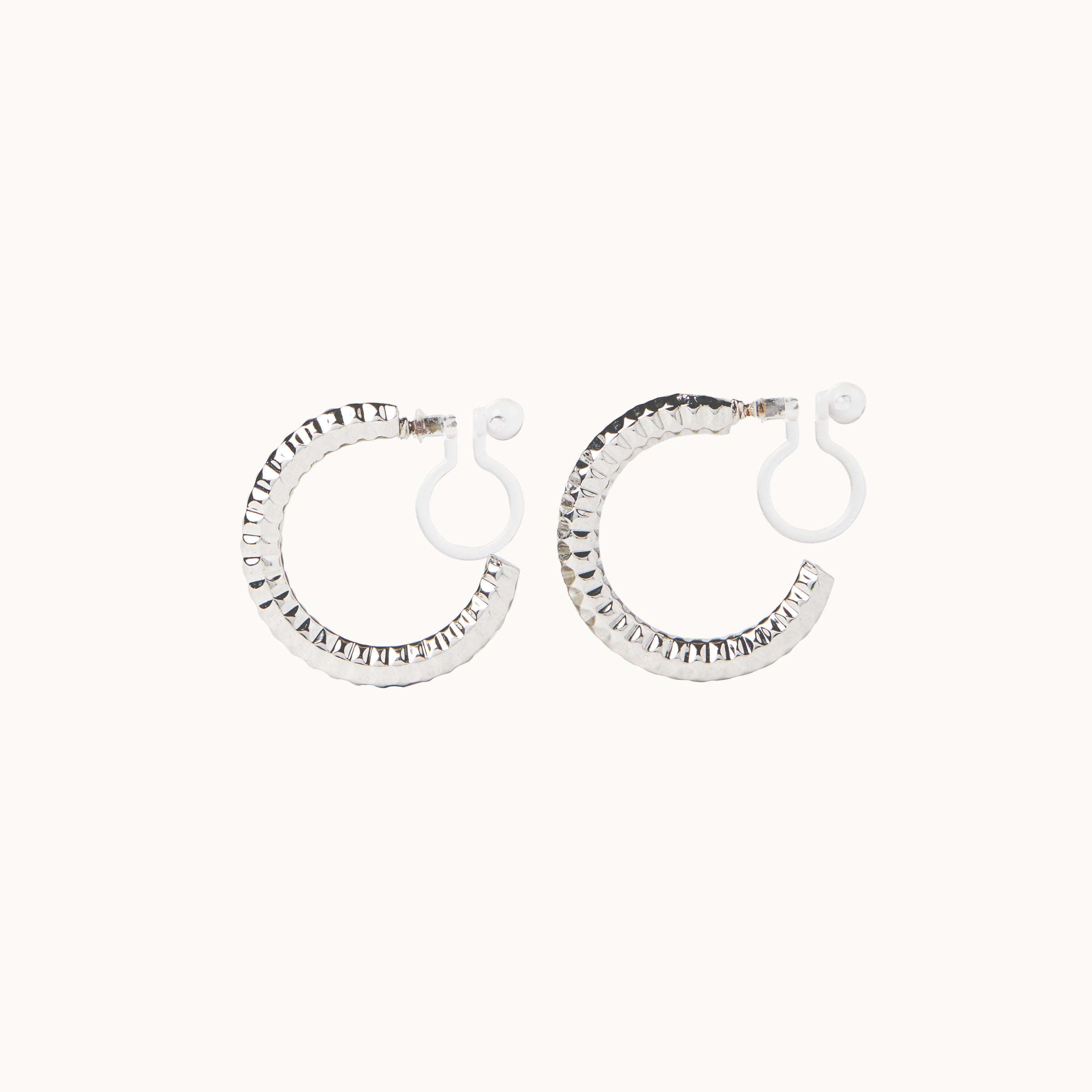 Image of the Ribbed Hoop Clip On Earrings in Silver. Made with a Resin Clip-On closure, these earrings provide a secure hold for 8-12 hours and are suitable for all ear sizes and types. Elevate your look with these versatile and long-lasting earrings. Set includes one pair.