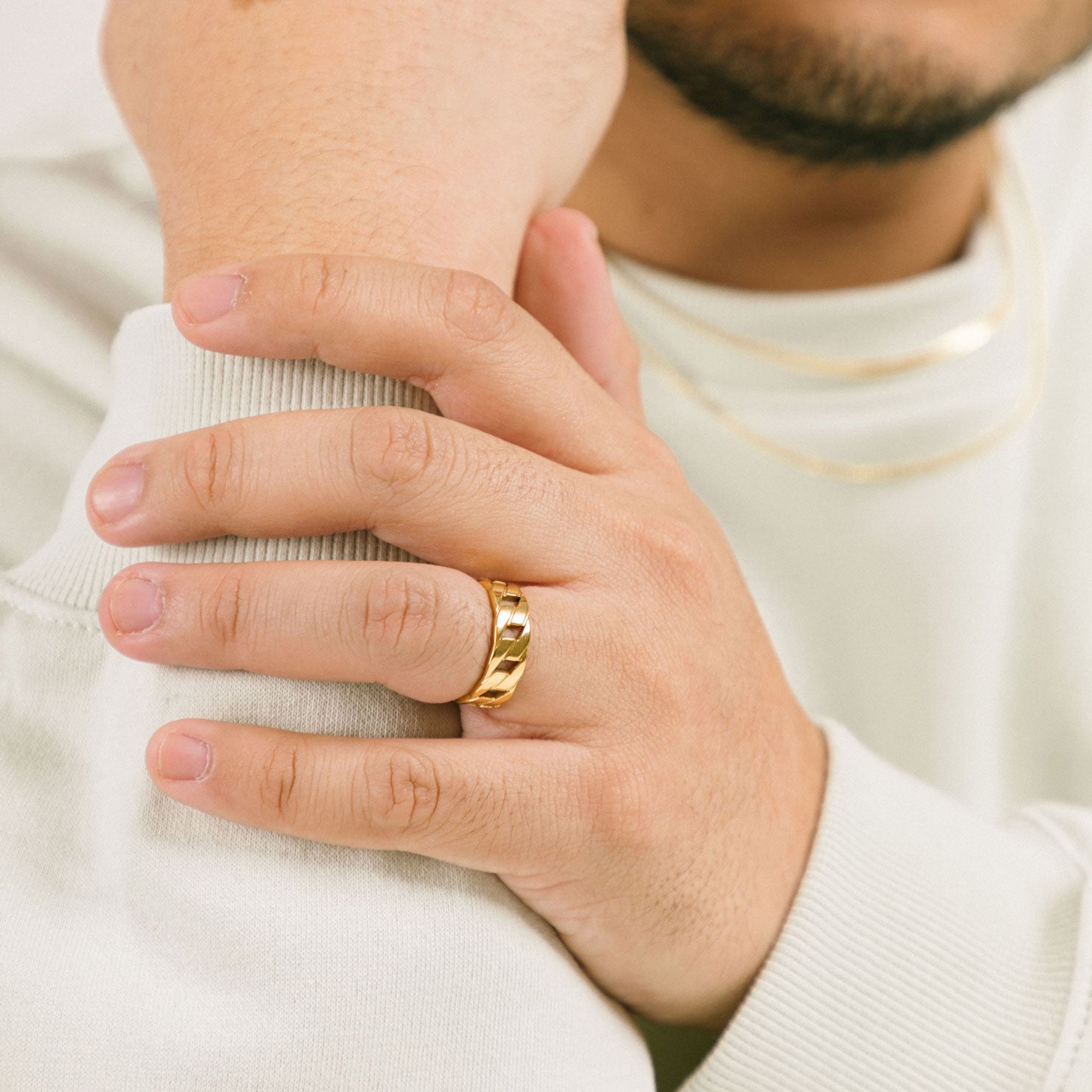 A model wearing the Cuban Link Chain Ring, crafted with 18K gold plating on stainless steel, delivering dependable protection from discoloration and water damage. Its unique design exudes a fashionable air, certain to make an impression.