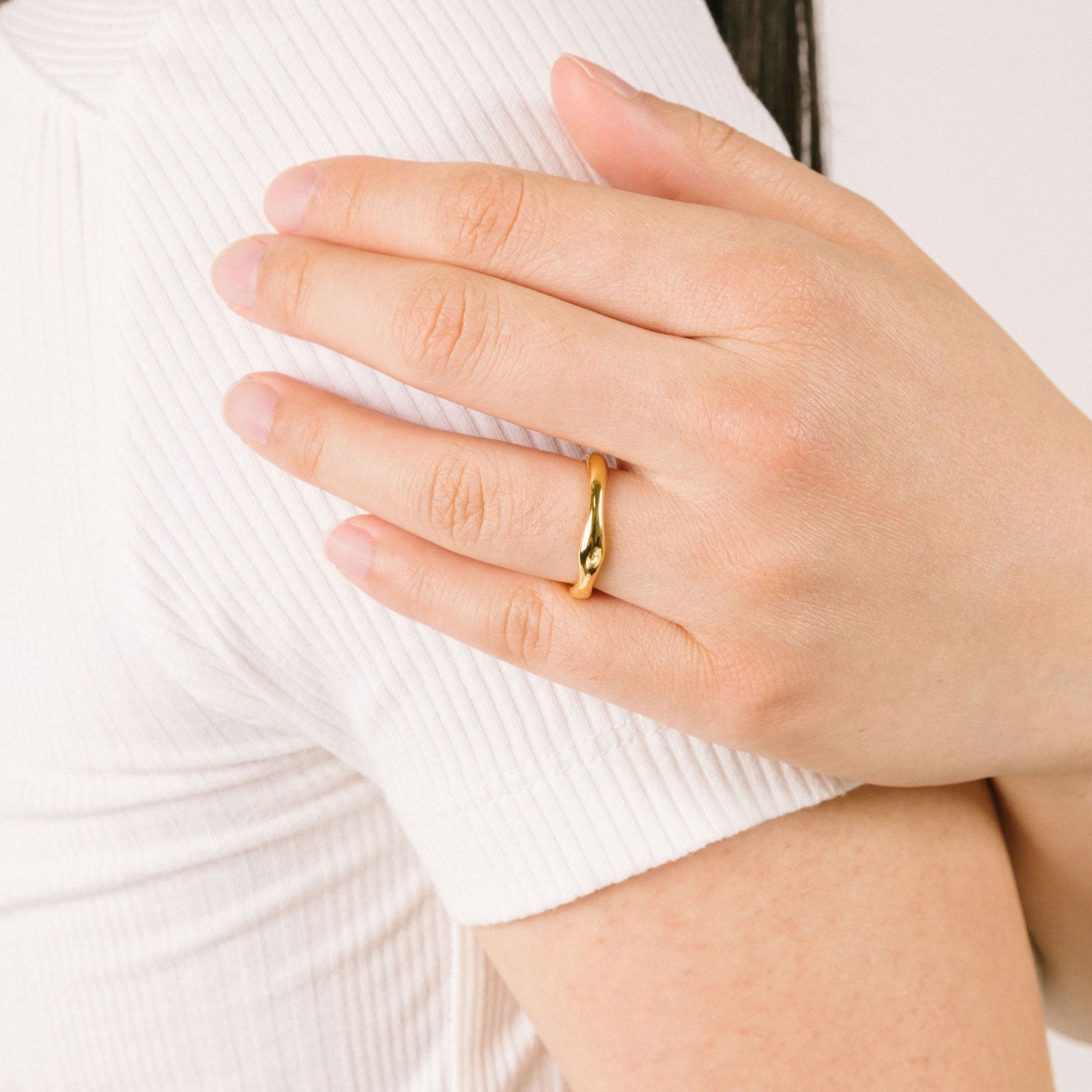 A model wearing the Organic Wave Ring offers no ability to adjust and is a single item comprised of 18K Gold Plated Stainless Steel, making it non-tarnish and water resistant.