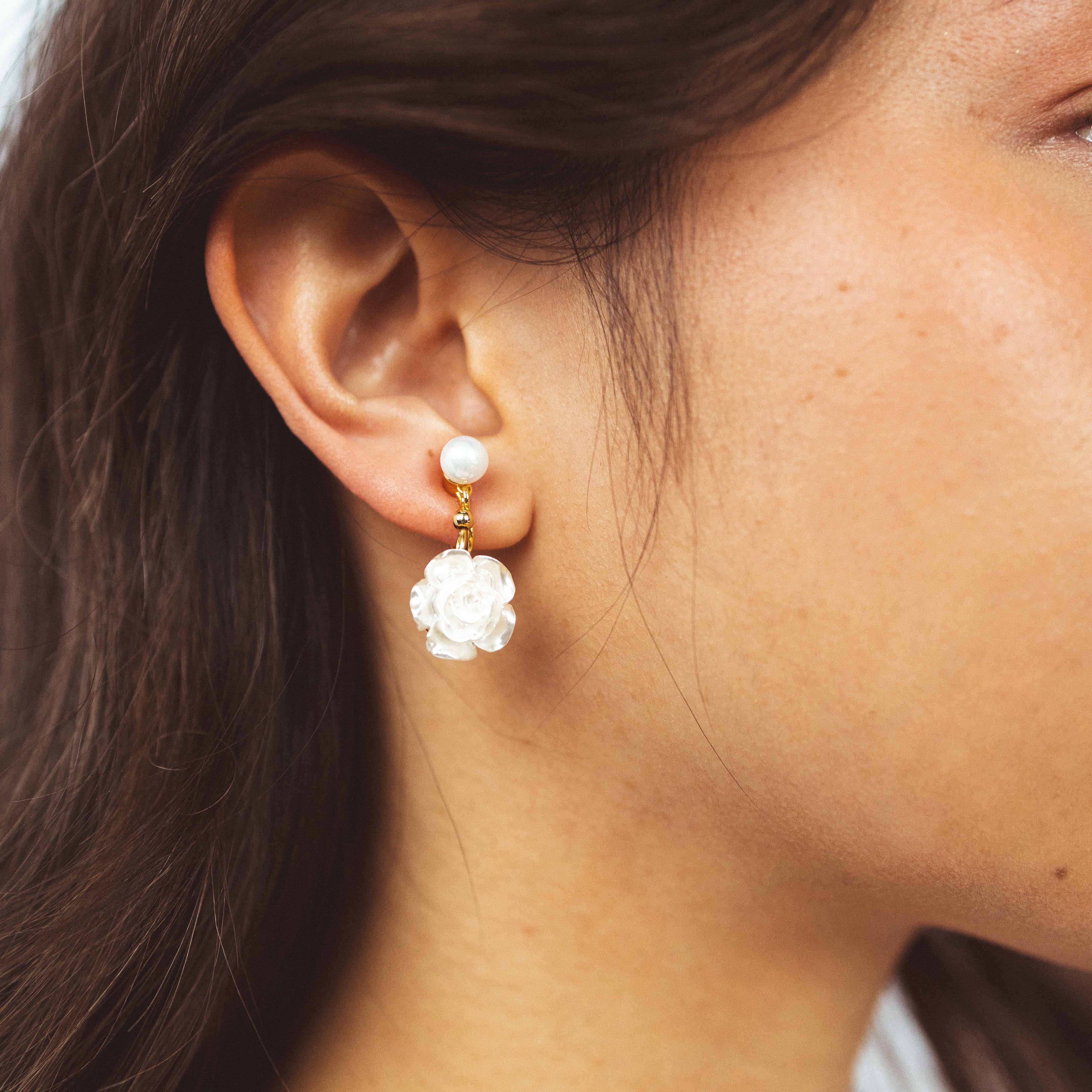 A model wearing the Rosemary Clip On Earrings. These earrings provide a secure hold for up to 24 hours and are easily adjustable for all ear types. Elevate your style without sacrificing comfort with these must-have accessories.