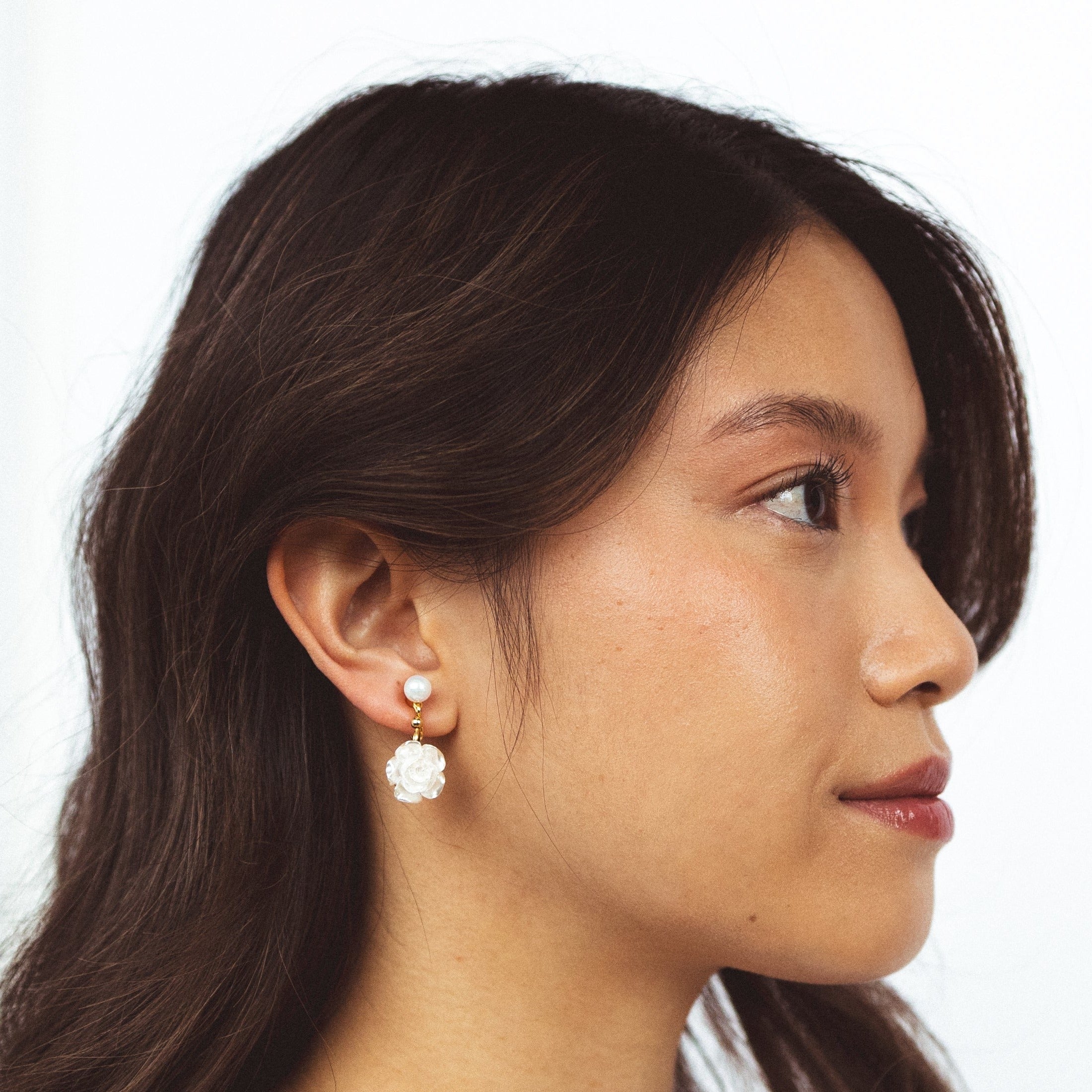 A model wearing the Rosemary Clip On Earrings. These earrings provide a secure hold for up to 24 hours and are easily adjustable for all ear types. Elevate your style without sacrificing comfort with these must-have accessories.