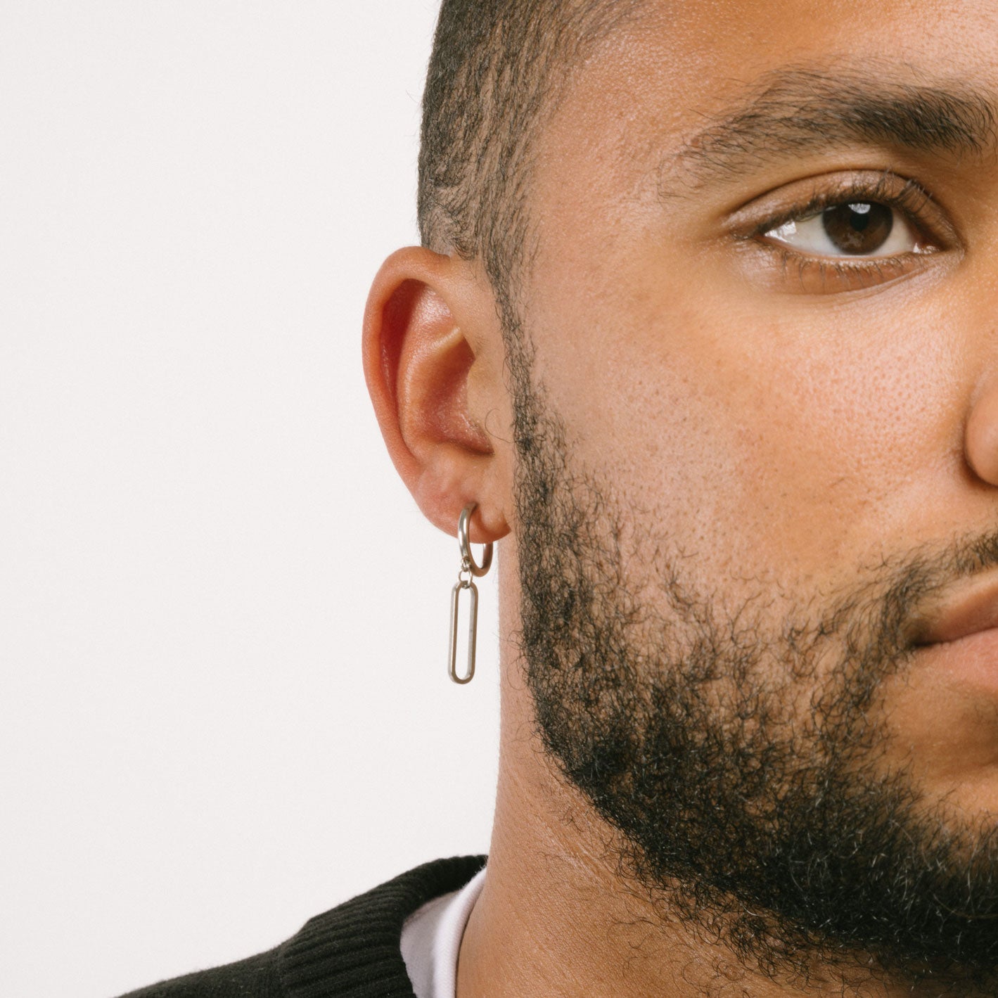 A model wearing the Silver Chain Clip On Earrings feature a sliding spring closure type which is optimal for those with small or thin ear lobes. These earrings provide a secure hold for up to 4 hours and automatically adjust to ear thickness. As an added bonus, they are non-tarnishing and water resistant. Note, item includes one pair.