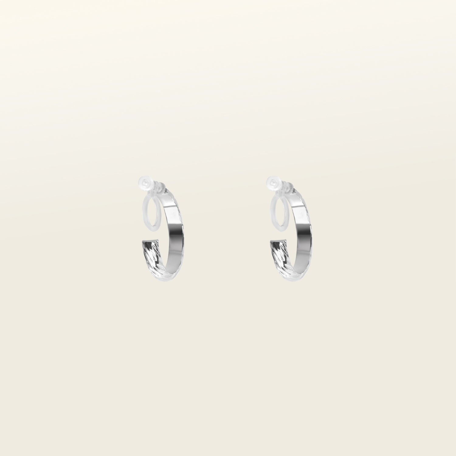 Image of the Silver Talia Hoop Clip-On Earrings boast a strong, medium-secure hold. They are crafted from a silver-tone alloy and feature a resin closure. They can be worn comfortably for 8-12 hours and are versatile enough for all ear shapes and sizes, including thick/large, sensitive, small/thin, and stretched/healing ears. An identical version is also available in Gold.