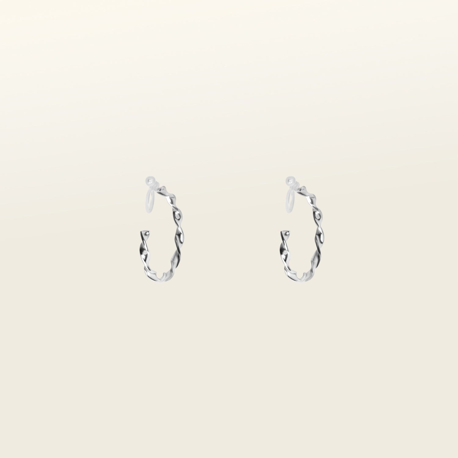 Image of the Silver Wave Hoop Clip-On Earrings are perfect for all ear types. Whether you have thick or large ears, or sensitive, small or thin ears, these earrings offer a medium-secure hold and can be comfortably worn for 8-12 hours. The earrings are made of silver-tone metal alloy and offer no ability to adjust - each purchase is for one pair. You can also find these earrings in a gold version.