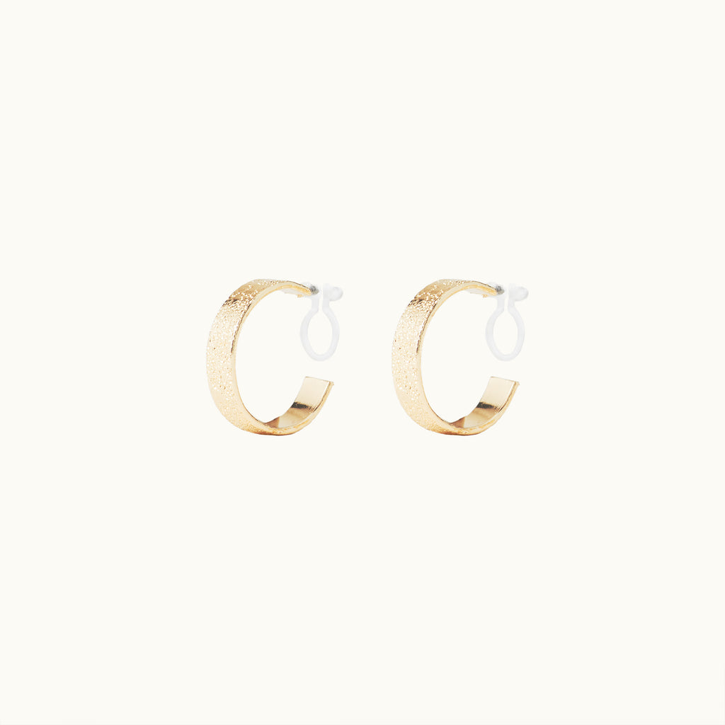 Image of the Speckled Hoop Clip On Earrings in Gold offer versatility and comfort for a range of ear sizes and sensitivities. With a medium secure hold, you can confidently wear them for 8-12 hours. Sold as a pair.