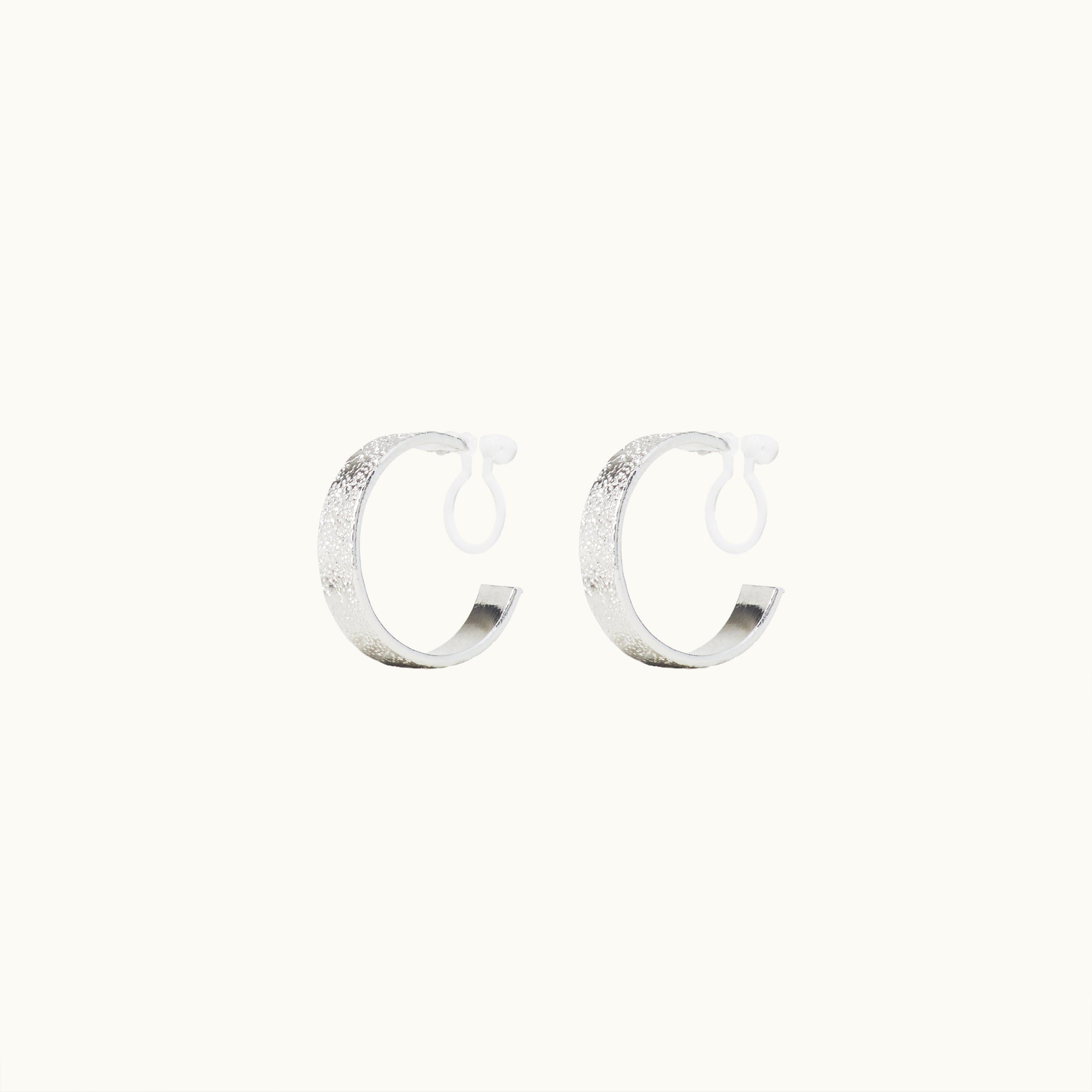 Image of the Speckled Hoop Clip On Earrings in Silver offer versatility and comfort for a range of ear sizes and sensitivities. With a medium secure hold, you can confidently wear them for 8-12 hours. Sold as a pair.