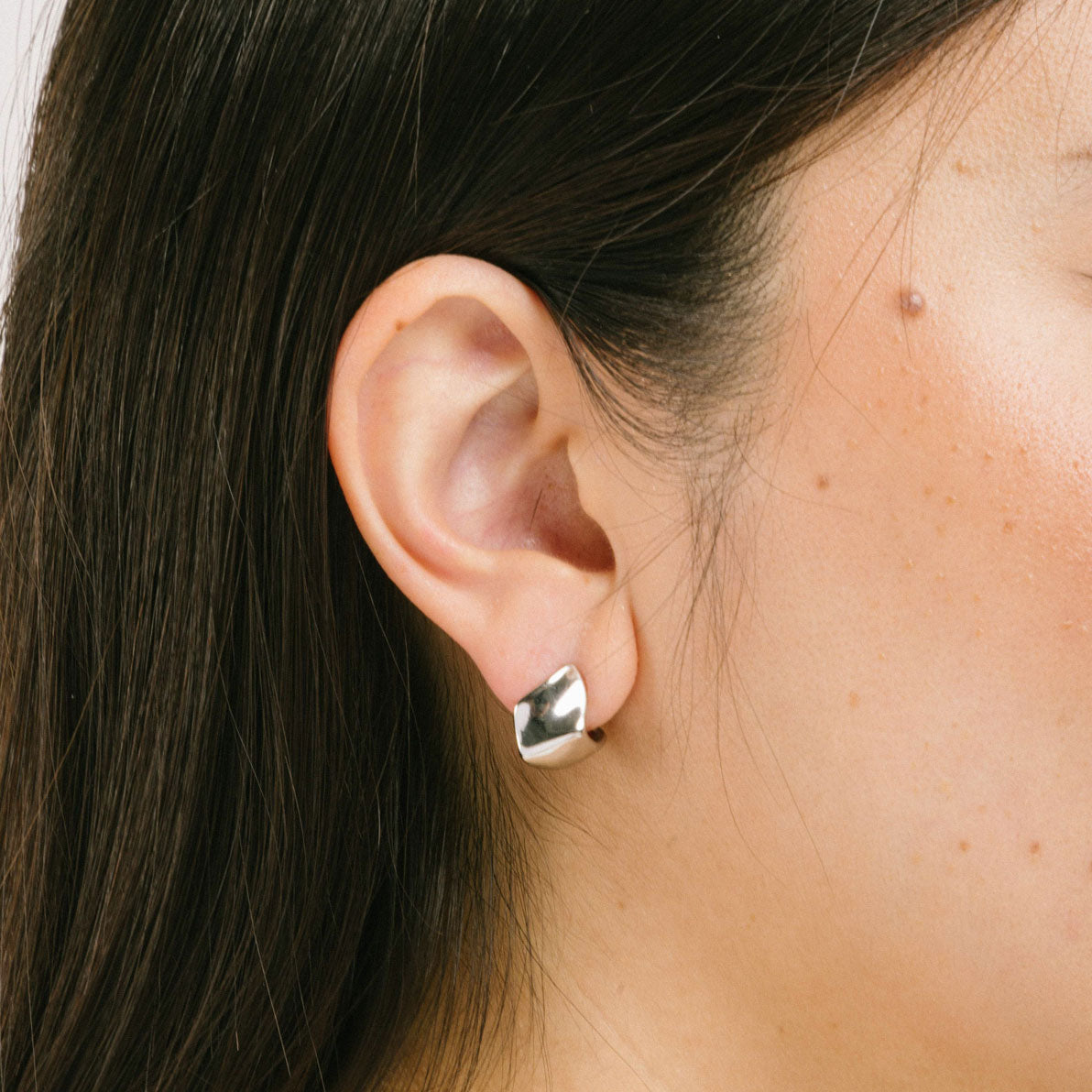 A model wearing the Spritz Clip On Earrings feature a Mosquito Coil Clip-On closure suitable for all ear types, offering a medium secure hold and adjustable comfort. On average, these earrings can be comfortably worn up to 24 hours. Constructed of Silver Toned Copper Alloy, one pair is included.