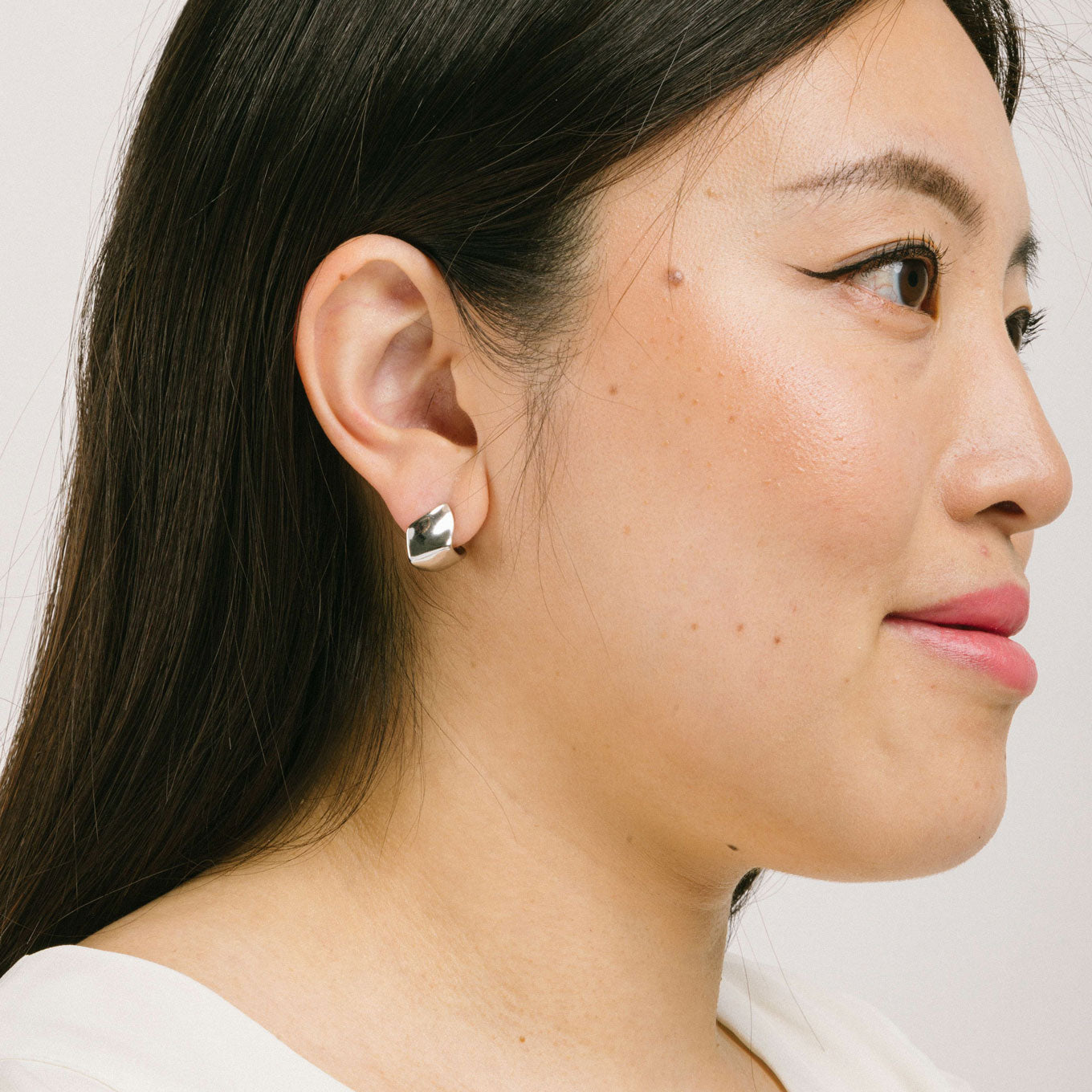 A model wearing the Spritz Clip On Earrings feature a Mosquito Coil Clip-On closure suitable for all ear types, offering a medium secure hold and adjustable comfort. On average, these earrings can be comfortably worn up to 24 hours. Constructed of Silver Toned Copper Alloy, one pair is included.