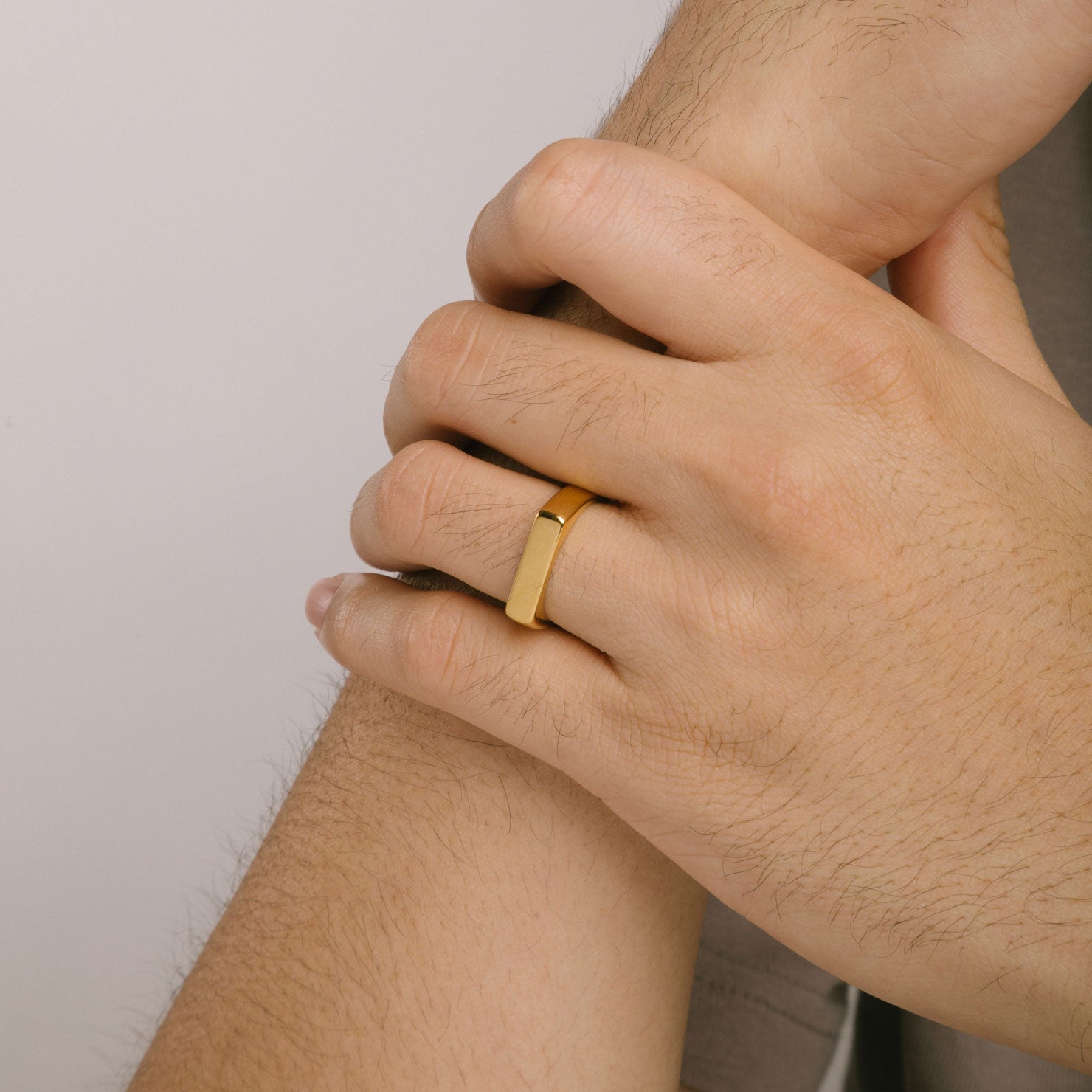 A model wearing the Straight Band Ring is crafted in 18K Gold Plated metal with a 4mm width and boasts non-tarnish and water-resistance properties.