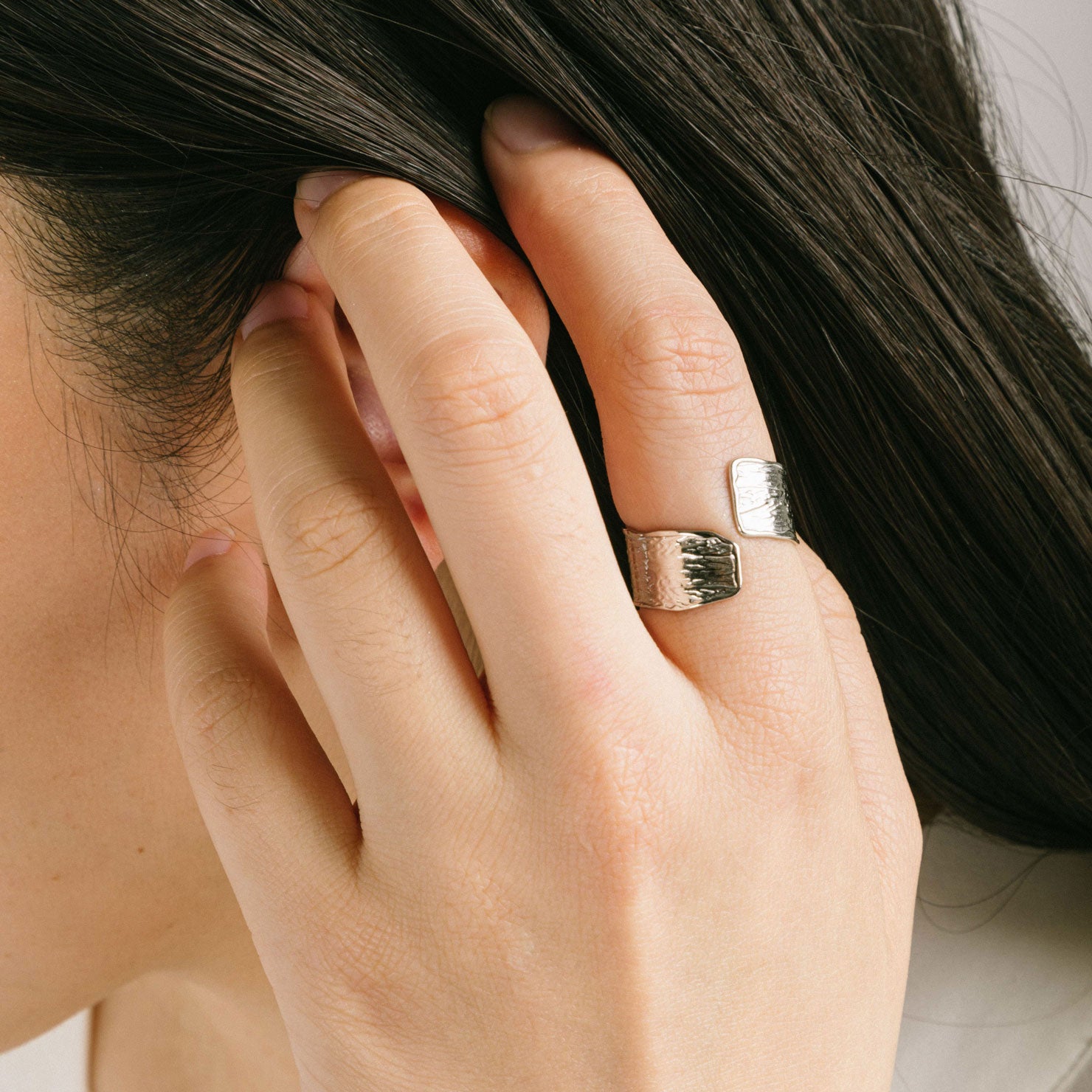 A model wearing the Textured Curl Ring in Silver offers adjustable sizing between 7-10, while crafted with stainless steel for long-lasting use. It is also water-resistant, non-tarnishing, and free of lead, nickel, and cadmium. Note: this is a single ring.