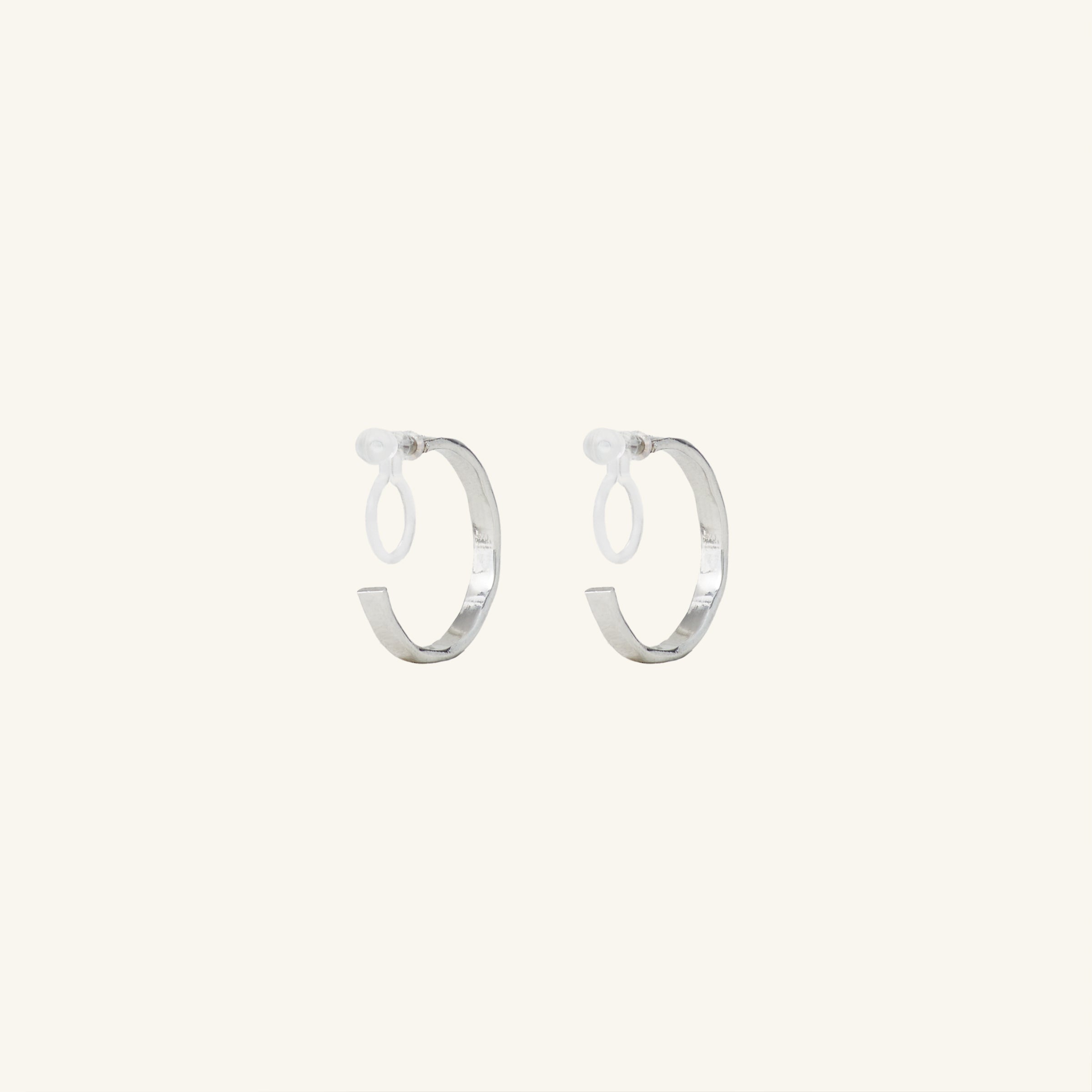 Image of the Tia Hoop Clip On Earrings in Silver are a must-have accessory. With a resin clip-on closure, they offer a secure hold for 8-12 hours of comfortable wear. Perfect for sensitive or small ears, and even those with thick or large ears. Please note, one pair included.