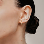 A model wearing the Tiny Hoop Clip On Earrings in Gold offer a Mosquito Coil Clip-On Closure, designed for comfort and versatility. Perfect for various ear types, they provide a secure hold and comfortable wear for 24 hours.