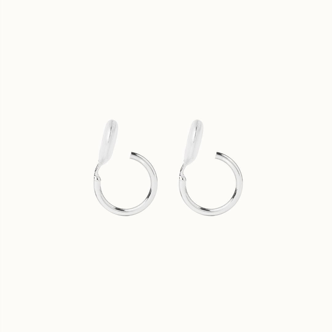 Image of the Tiny Hoop Clip On Earrings in Silver offer a Mosquito Coil Clip-On Closure, designed for comfort and versatility. Perfect for various ear types, they provide a secure hold and comfortable wear for 24 hours. 