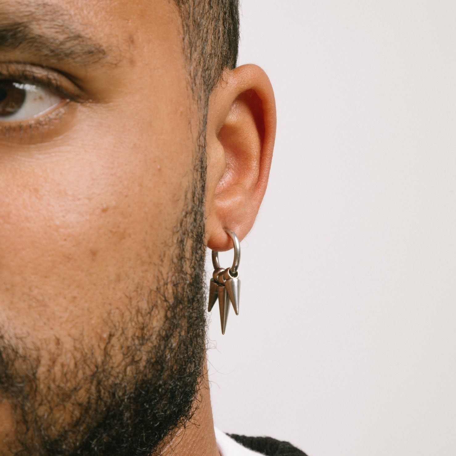 A model wearing the Triple Dangle Clip-On Earrings feature sliding spring closure, ideal for those with smaller or thinner ear lobes. Average comfortable wear duration estimated at 2 - 4 hours, with a secure hold. Earrings also have adjustable mechanism to ensure proper fit to ear thickness. Crafted with stainless steel, comes in one pair.