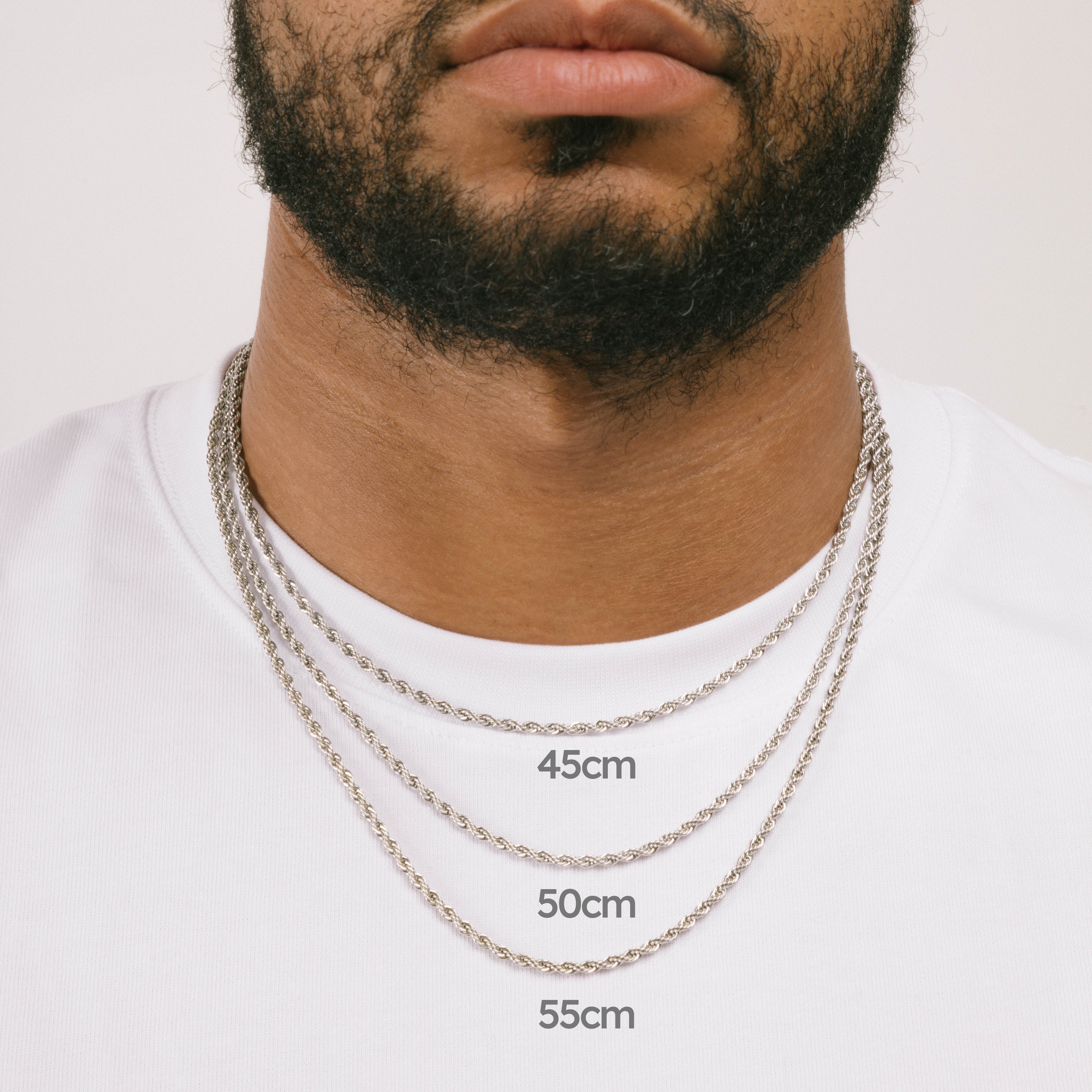 A model wearing the Twisted Rope Chain in Silver is crafted from durable stainless steel. It measures 45cm, 50cm, or 55cm in length and 3mm in width. Additionally, it is non-tarnishing, water-resistant, and safe for those with allergies.