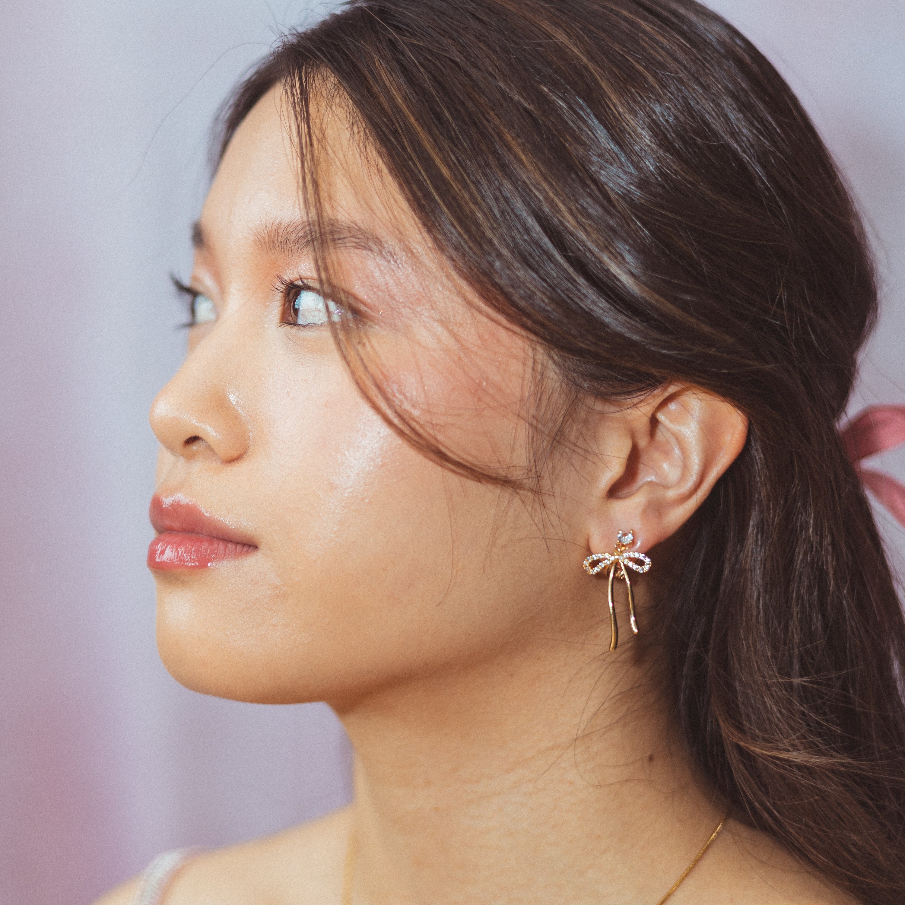 A model wearing the Anna Clip On Earrings, offer an adjustable fit and 24-hour hold for unrivaled comfort. Elevate your style effortlessly with the touch of elegance these earrings provide.