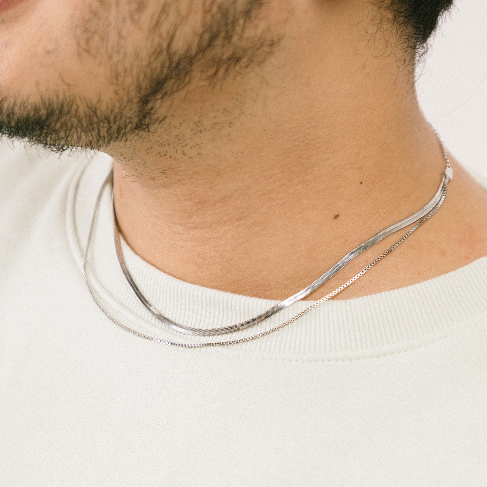 A model wearing the Double Layered Chain Necklace In Silver is adjustable, constructed of stainless steel and is waterproof and non-tarnish. It is also available in Gold.