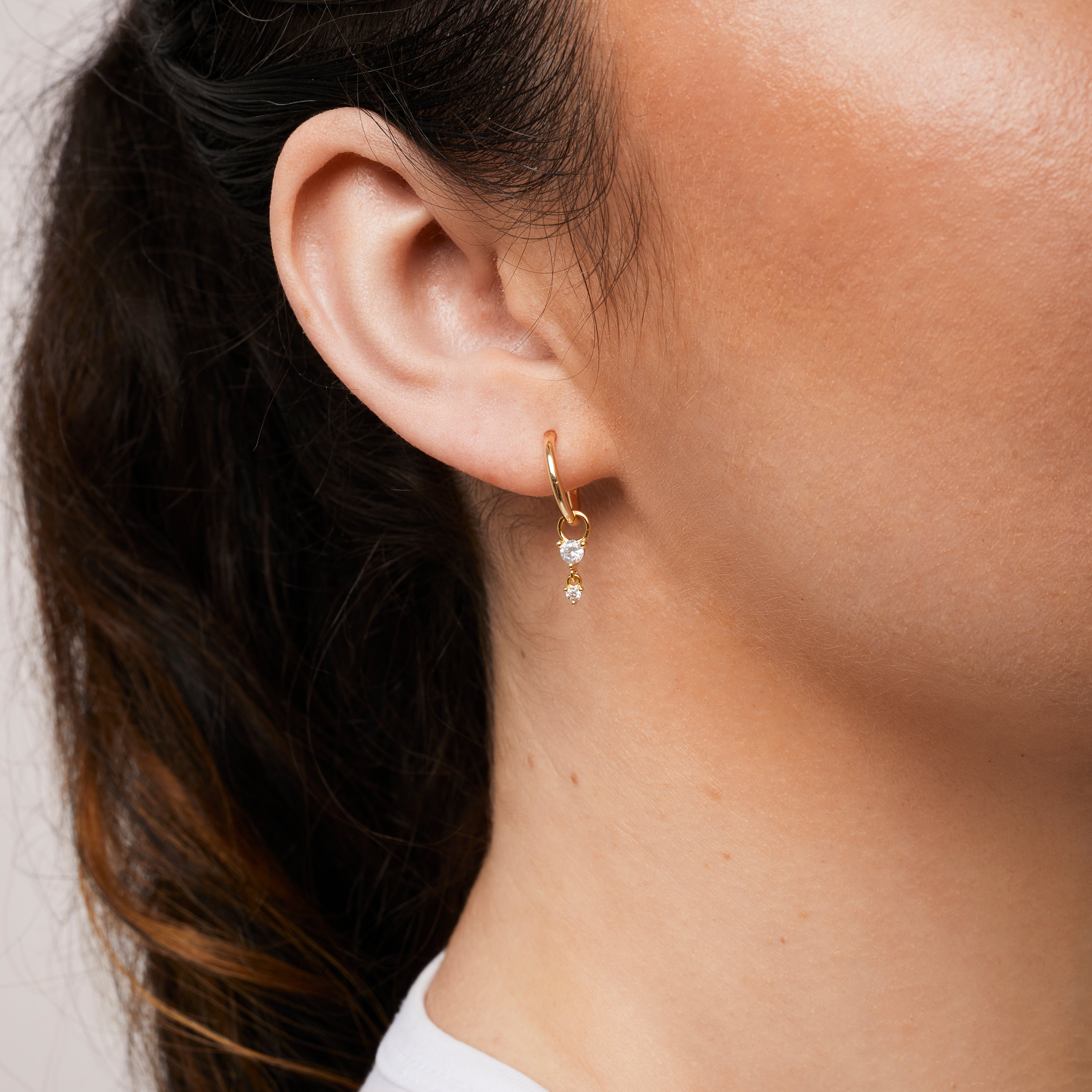 A model wearing the Cluster Hoop Charms in Gold are made with high-quality materials, including 18K gold plating over 925 Sterling Silver. These charms are both non-tarnish and water resistant. The perfect combination of style and durability.
