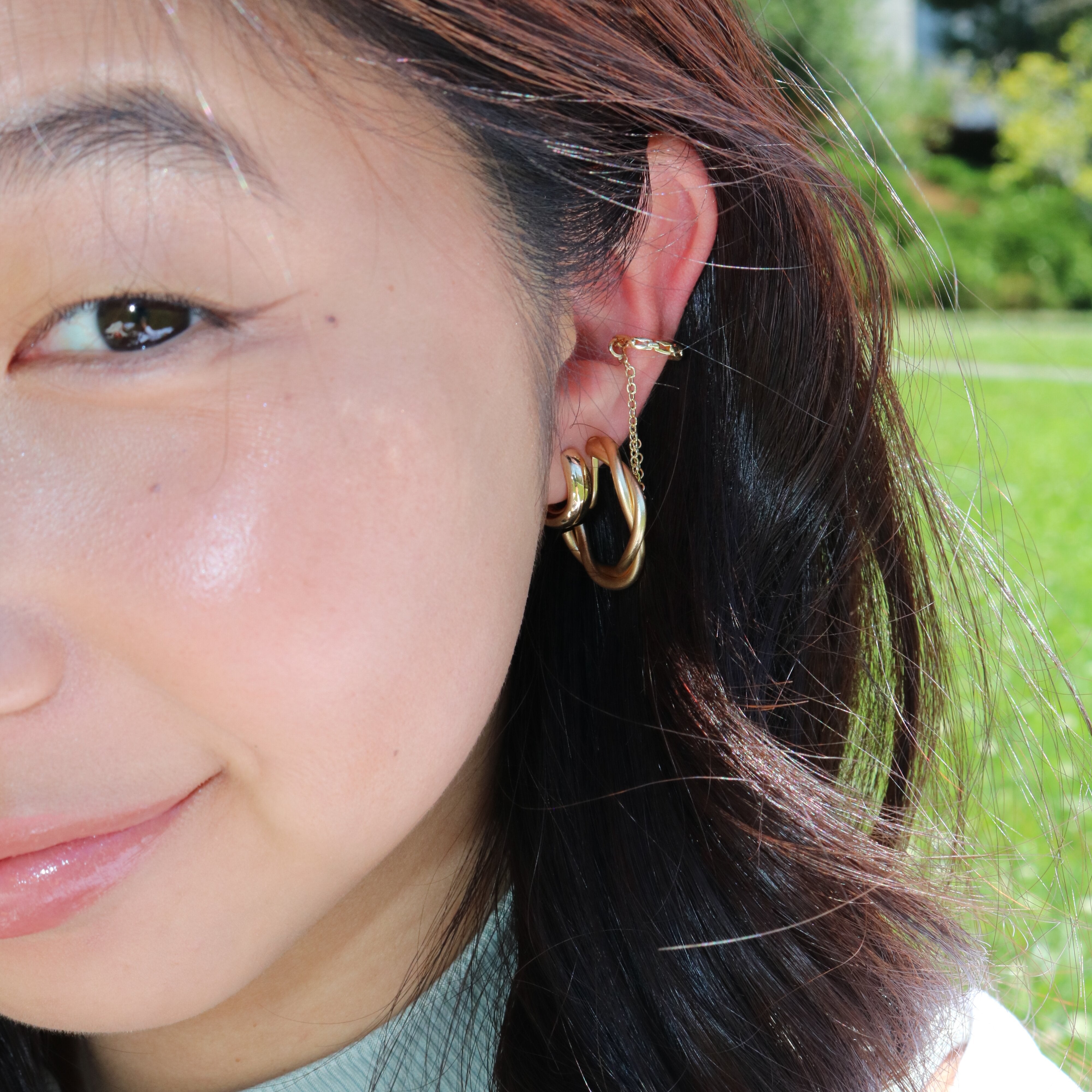 Model Image of a modern Dual Chain Ear Cuff crafted from Goldtone or Silvertone plated zinc alloy. This trendy accessory features a delicate chain, designed to elegantly adorn the earlobe of both men and women.