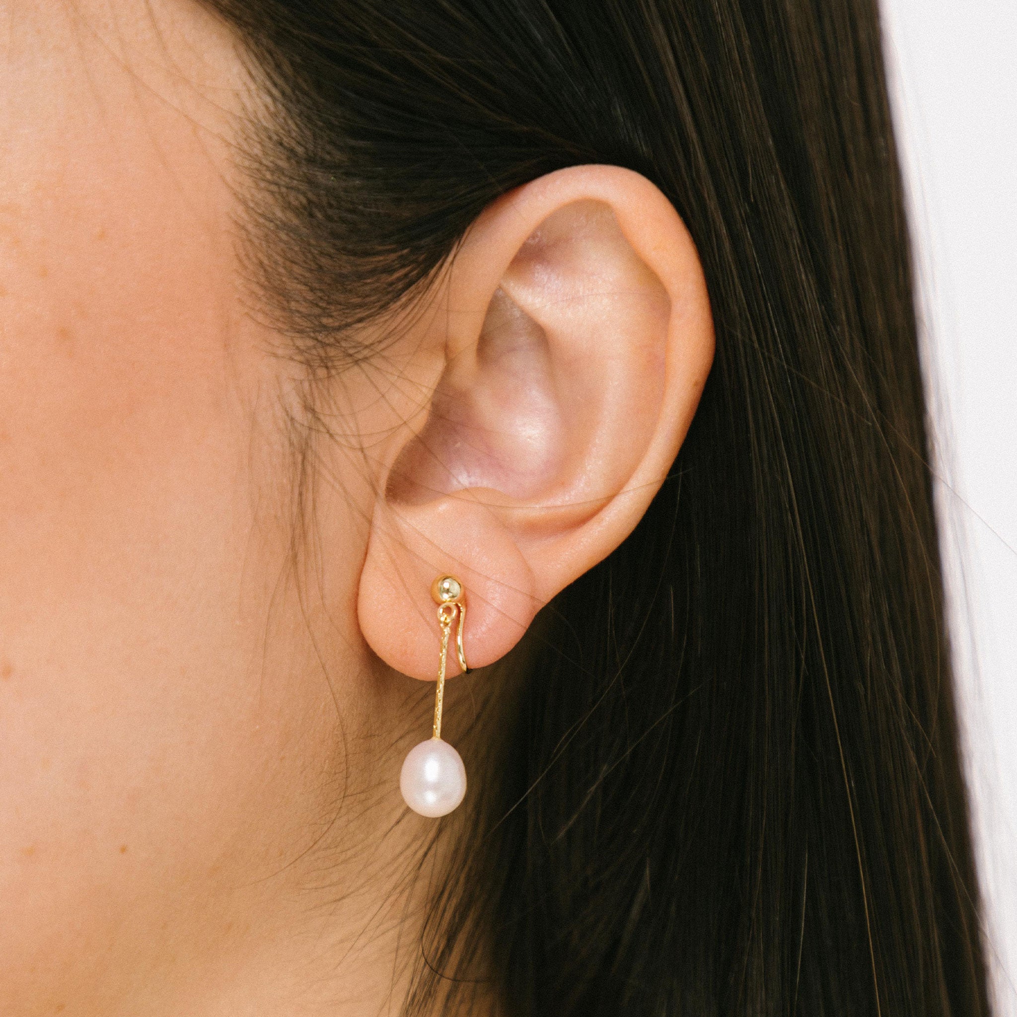 Sophisticated gold-plated clip-on earrings showcasing lustrous freshwater pearls. Suitable for all ear types, including thick and small ears. Can be worn comfortably for up to 24 hours. 