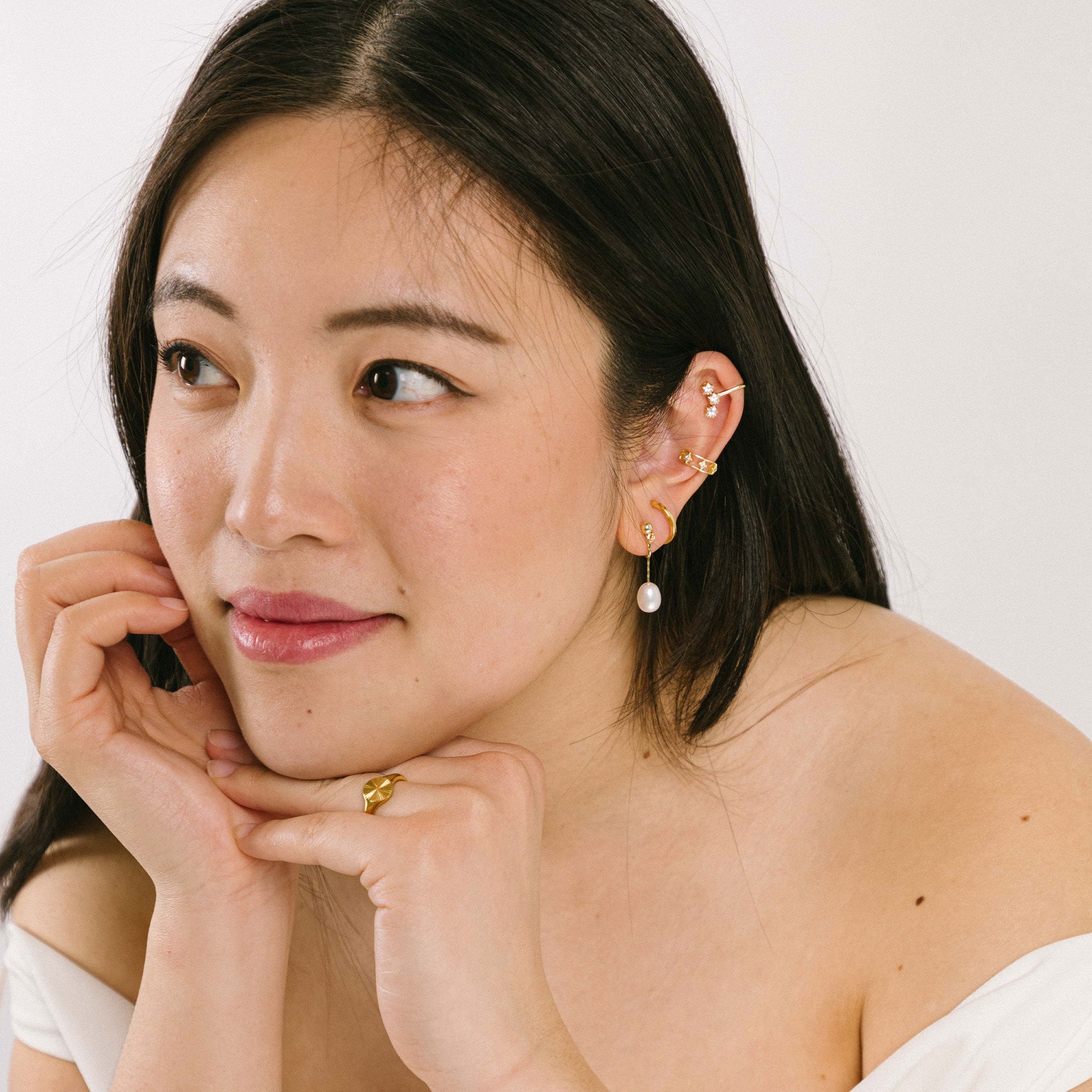 Model wearing Adriene Pearl Clip-On Earrings with freshwater pearls on 18K gold-plated stainless steel. Perfect for all ear types, offering a medium secure hold. Easily adjustable for a customized fit. 
