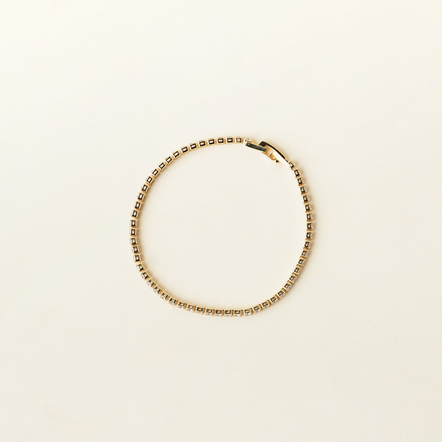 Image of the Tennis Bracelet is an exquisite companion to its sister piece, the Classic Tennis Necklace. Meticulously constructed from 14K gold plated metal, it is embellished with shimmering Cubic Zirconia stones. Additionally, its design is exceptionally enduring - it is tarnish-resistant, water-resistant, nickel-free, and hypoallergenic.