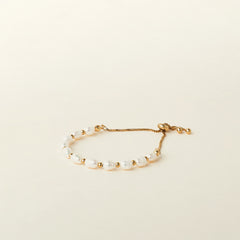 Image of the Emi Pearl Bracelet is crafted from 18K Gold Plated Stainless Steel and Freshwater Pearls, allowing for a small degree of variation in size and hue. The bracelet is water-resistant and hypoallergenic.