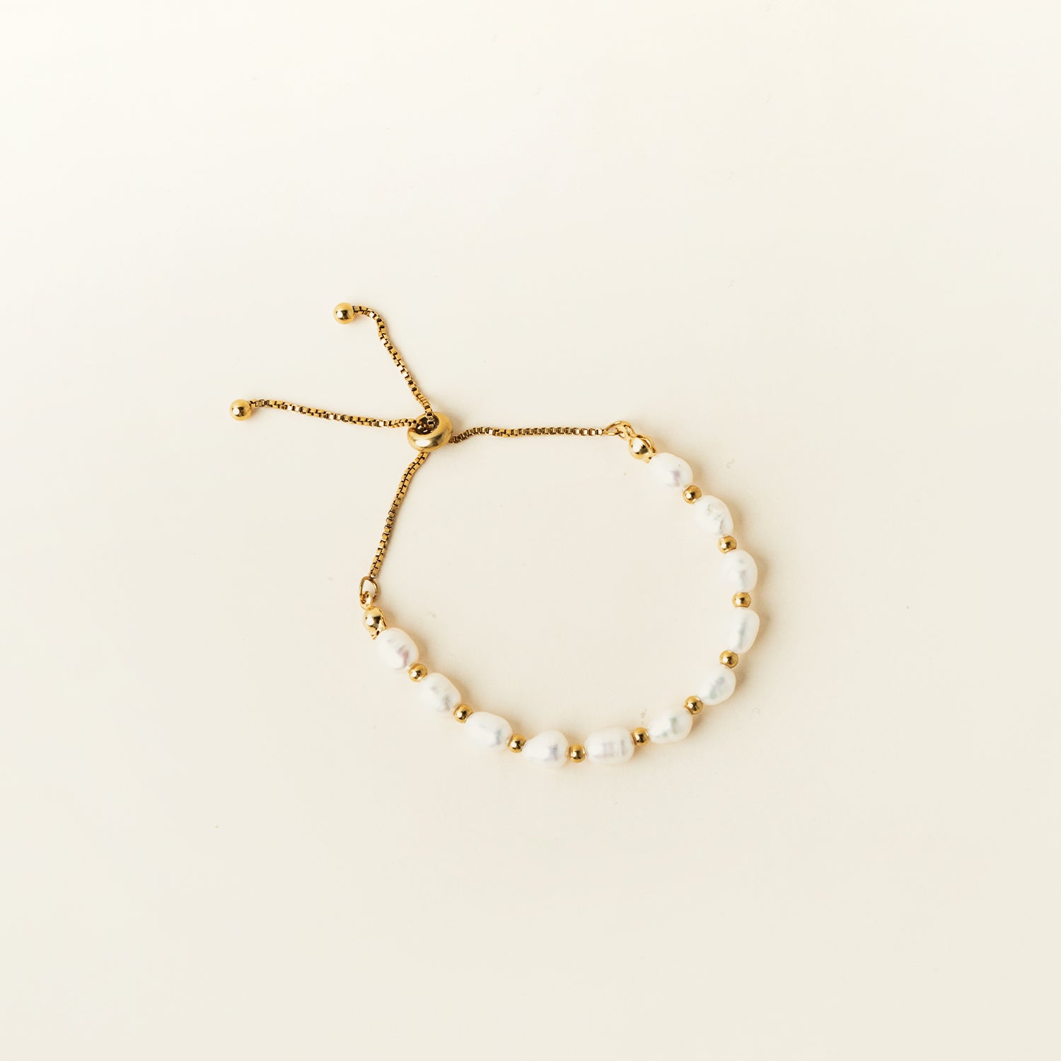 Image of the Emi Pearl Bracelet is crafted from 18K Gold Plated Stainless Steel and Freshwater Pearls, allowing for a small degree of variation in size and hue. The bracelet is water-resistant and hypoallergenic.