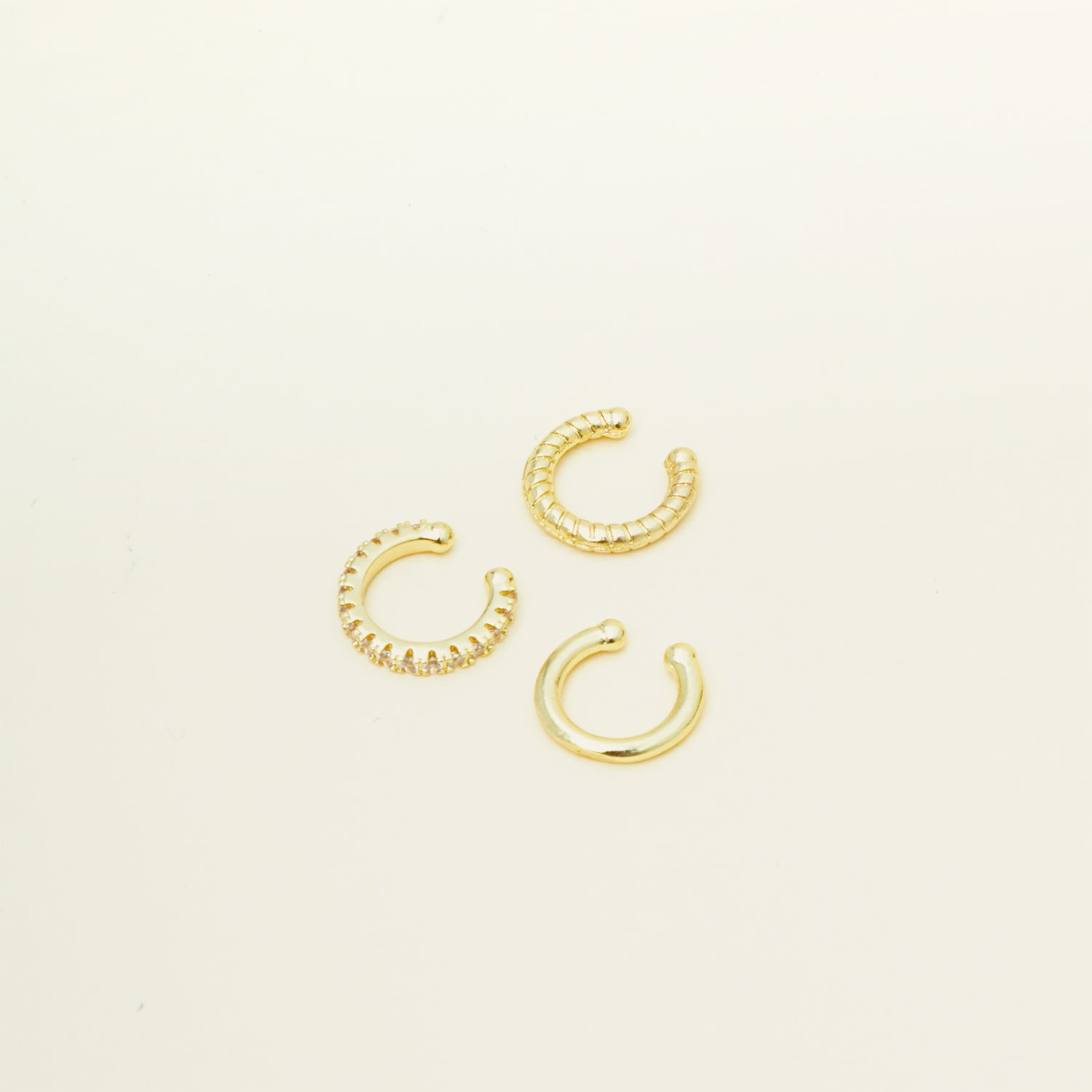 Image of the set includes three pieces of ear cuffs finished in gold-tone plated alloy with cubic zirconia accents. This set is also available in silver.