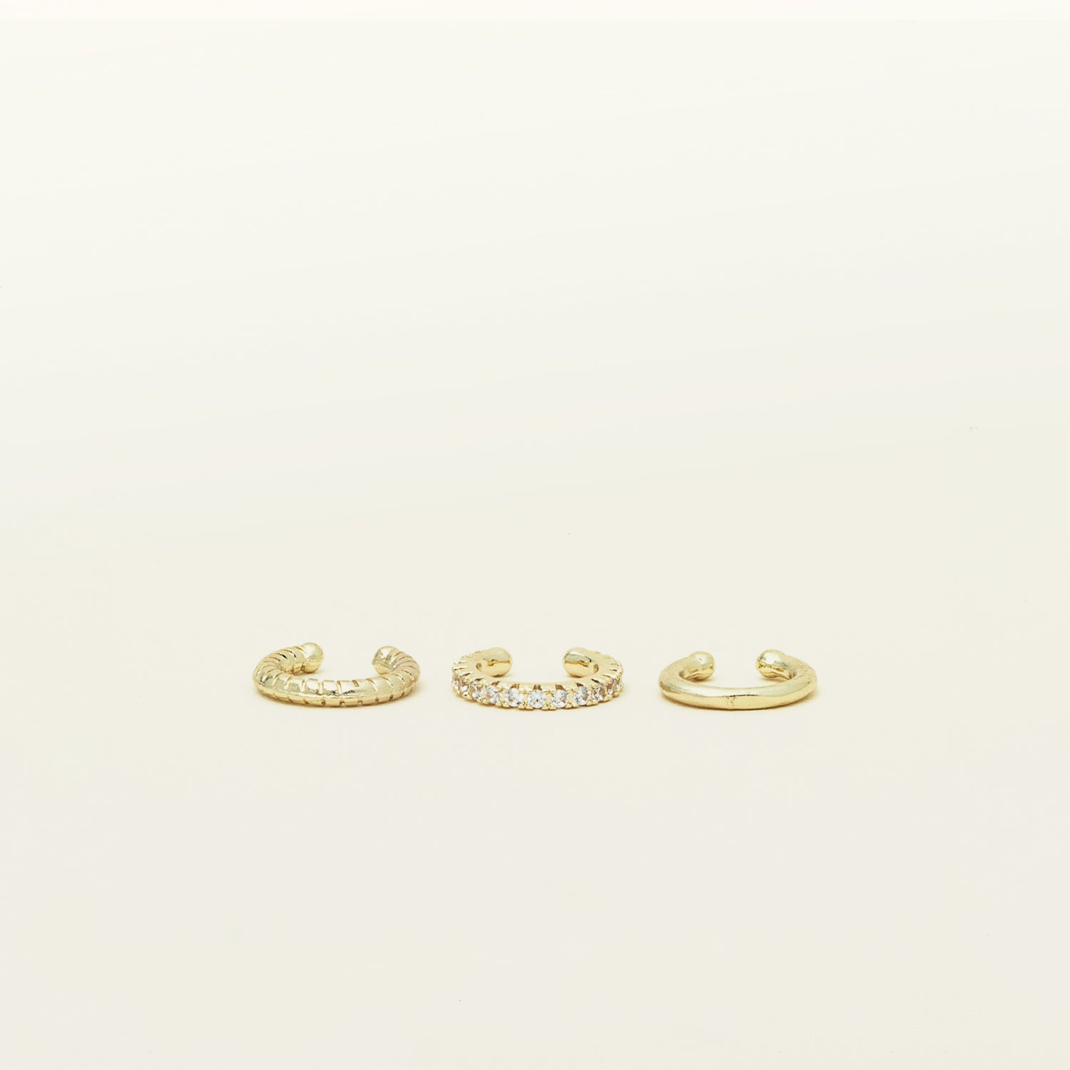 Image of the set includes three pieces of ear cuffs finished in gold-tone plated alloy with cubic zirconia accents. This set is also available in silver.
