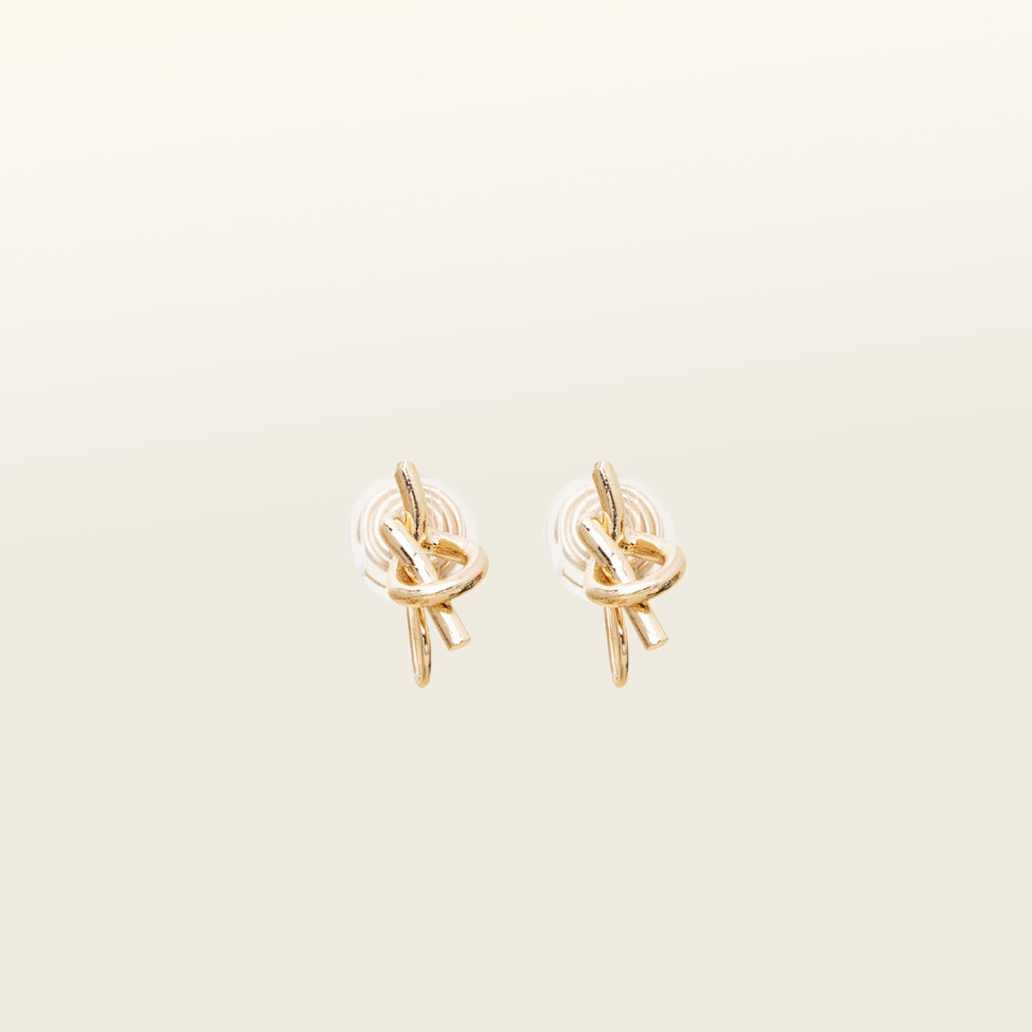 Image of the Knot Clip-On Earrings, a must-have accessory to elevate your style. These modern earrings are crafted from gold tone plated metal alloy, showcasing a chic knot shape. Designed for comfort, they come with a convenient mosquito coil closure and backings with paddings. With a perfect blend of classic and contemporary, these earrings add a touch of sophistication to any outfit, making them an essential addition to your jewelry collection.
