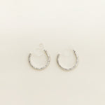 Image of the Silver Talia Hoop Clip-On Earrings boast a strong, medium-secure hold. They are crafted from a silver-tone alloy and feature a resin closure. They can be worn comfortably for 8-12 hours and are versatile enough for all ear shapes and sizes, including thick/large, sensitive, small/thin, and stretched/healing ears. An identical version is also available in Gold.