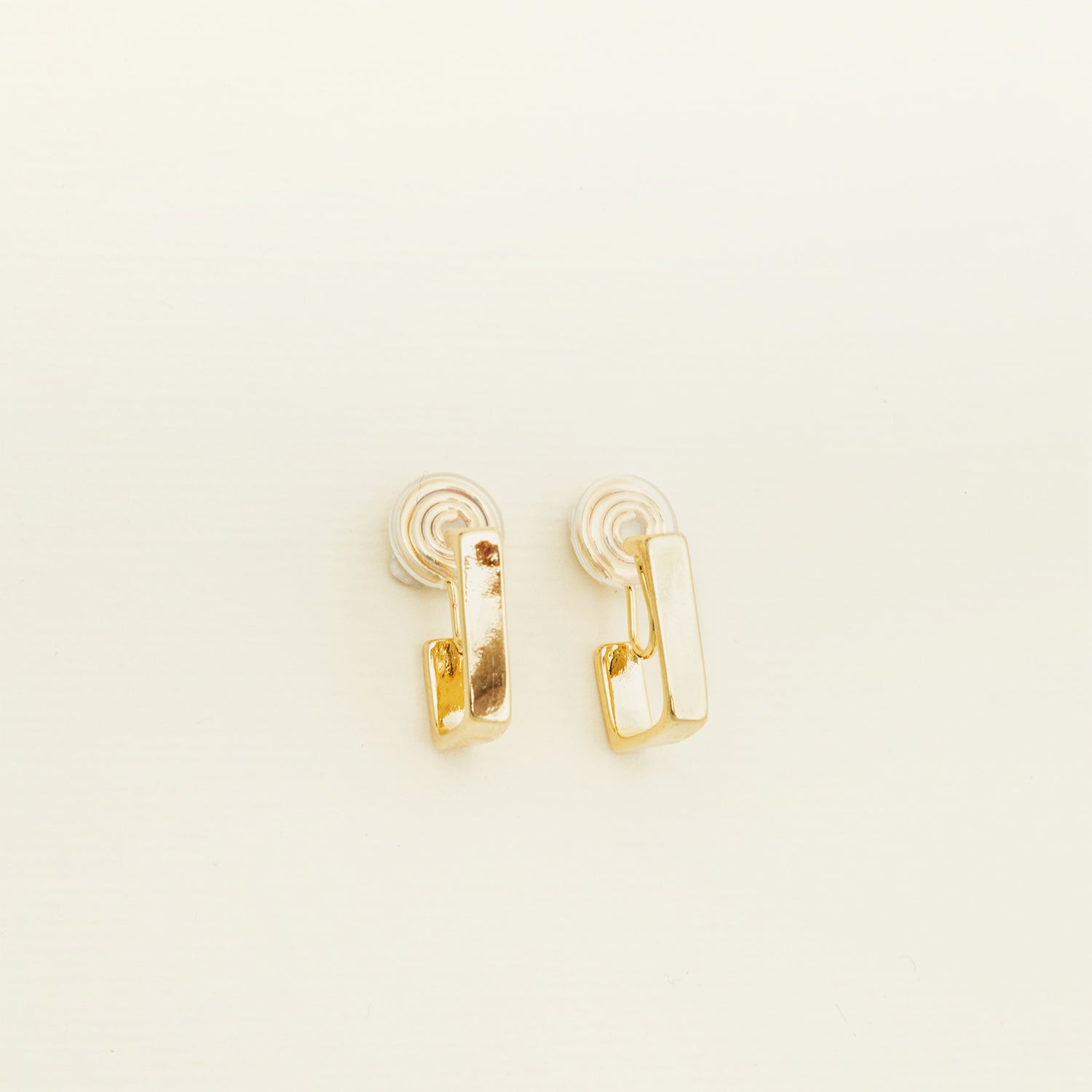 Catalogue image of a Classic Square Huggie Hoop Clip-On Earrings - 14k Gold plated metal alloy, non-tarnish, and water-resistant. Modern square clip-on design with mosquito coil closure and paddings for a secure, comfortable fit all day.