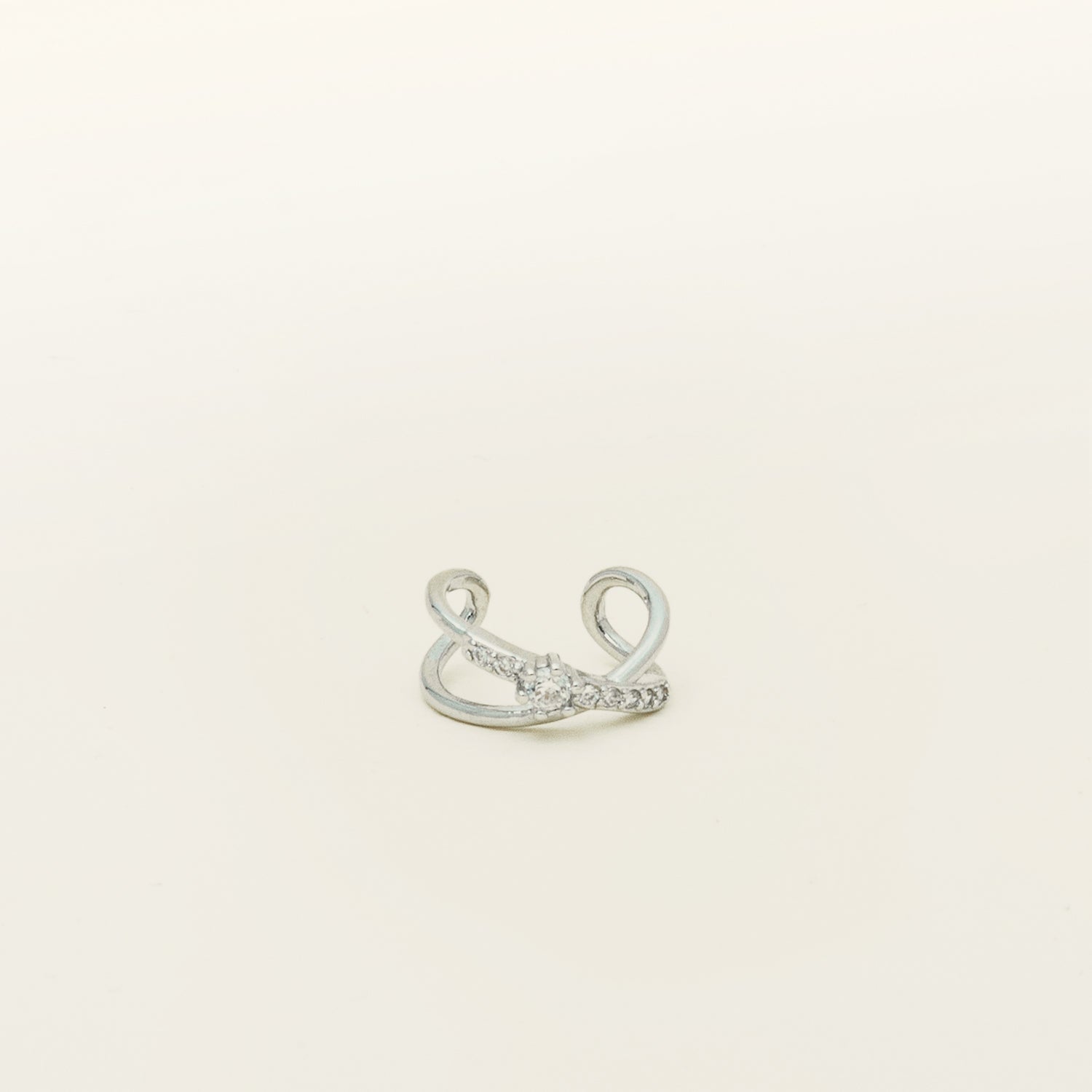 Image of the Supernova Ear Cuff, a sophisticated and stylish statement piece. Crafted from premium Sterling Silver (S925) in an elegant X shape, it boasts a prominent zirconia centerpiece and a row of smaller stones. This versatile accessory is perfect for the modern man or woman, exuding a touch of luxury and contemporary charm.