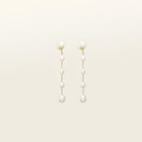 Image of the Lune Pearl Clip-On Earrings in Gold feature a unique, secure mosquito coil clasp. They are ideal for all ear types, from thick and large ears to sensitive and small. With medium hold strength, the earrings can be comfortably worn up to 24 hours and easily adjusted. Crafted with freshwater pearls, each pair may display natural variations in size and color. Materials include freshwater pearl and 18K gold-plated stainless steel.