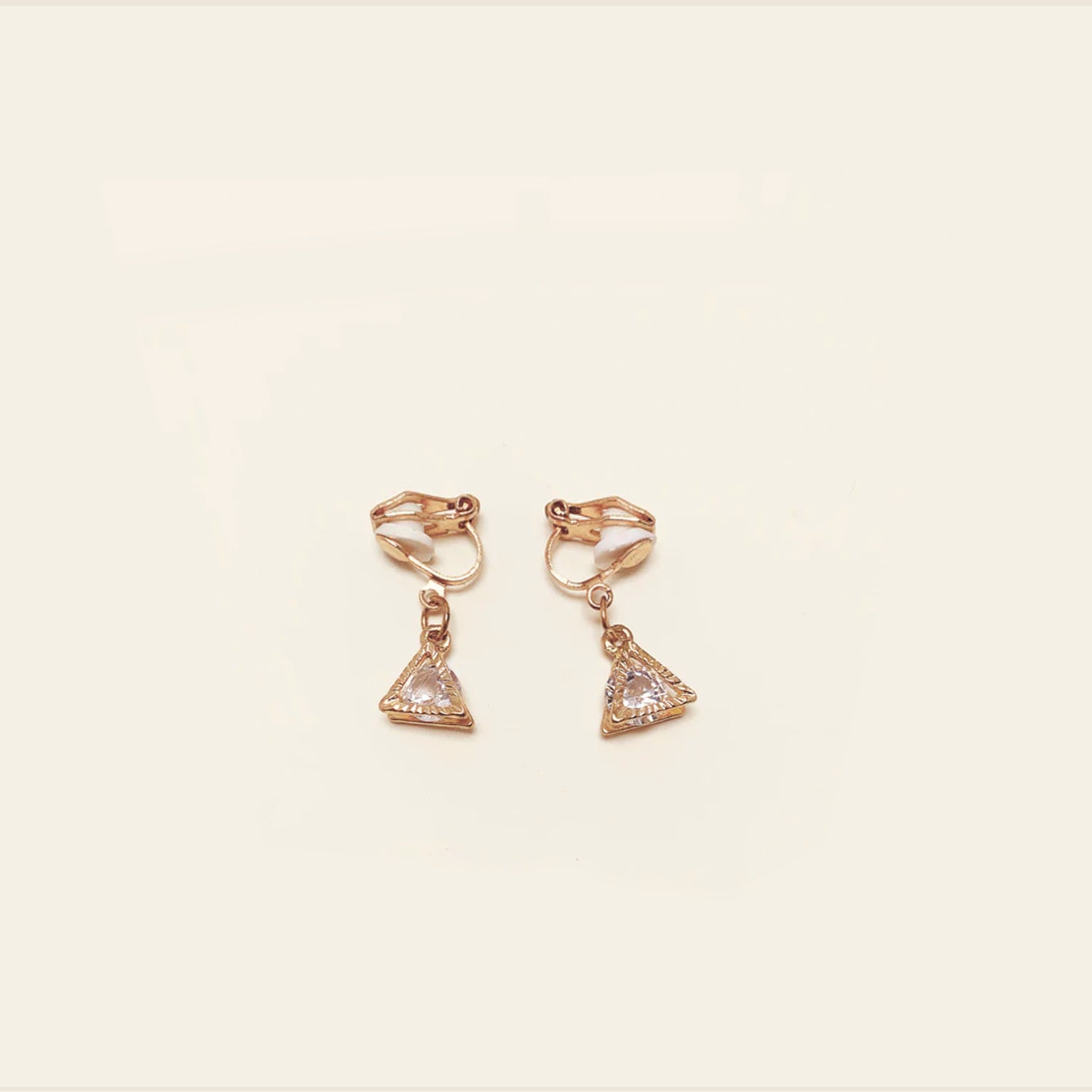 Image of the Cecile Clip-On Earrings. Make a stylish addition to any ensemble with their gold-tone plated zinc alloy and sparkle of cubic zirconia. The removable rubber padding ensures comfort for thick, large, sensitive, small, and thin ears.