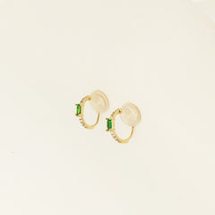 Image of the Emerald Pavé Huggie Clip-On Earrings features a closure type of mosquito coil clip-on earrings. They are suitable for all types of ear shapes and sizes, and are comfortable to wear for up to 24 hours. The hold strength is medium, allowing you to gently adjust the padding forward once on the ear. Crafted with 18k gold plated metal alloy and cubic zirconia, these earrings are non-tarnish and water-resistant.