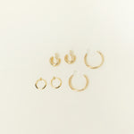 Image of the Everyday Essentials Set comes with three pairs of earrings featuring an Invisible Resin, Sliding Spring and Mosquito Coil closure. The set includes a Simple Gold Huggie Clip-On, Mini Hoop Earrings, and Gold Cassie Hoop Earrings, all crafted of Gold tone plated alloy, Stainless steel, or Gold Tone Metal Alloy. It is also available in Silver.