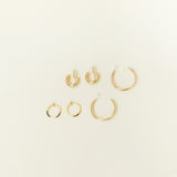 Image of the Everyday Essentials Set comes with three pairs of earrings featuring an Invisible Resin, Sliding Spring and Mosquito Coil closure. The set includes a Simple Gold Huggie Clip-On, Mini Hoop Earrings, and Gold Cassie Hoop Earrings, all crafted of Gold tone plated alloy, Stainless steel, or Gold Tone Metal Alloy. It is also available in Silver.