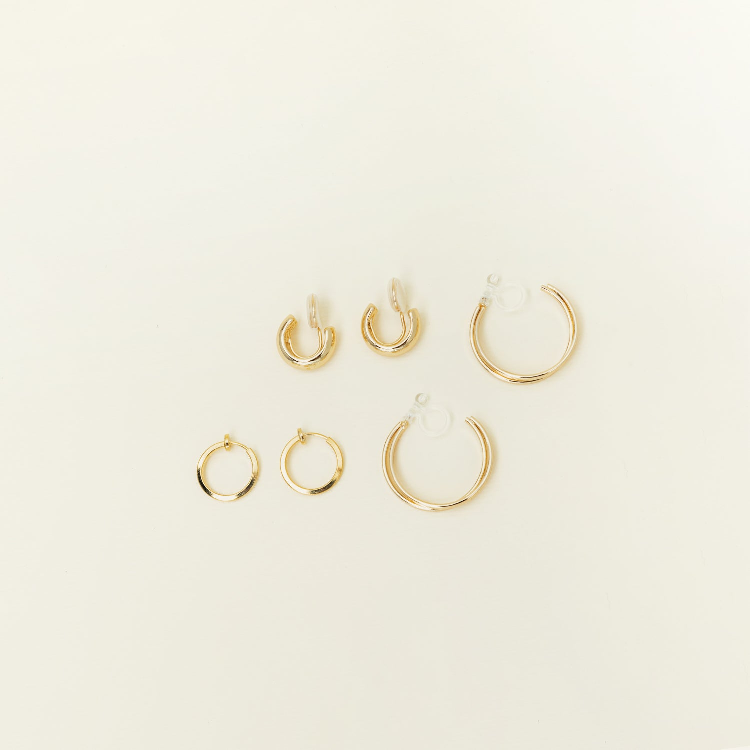 Image of the Everyday Essentials Set comes with three pairs of earrings featuring an Invisible Resin, Sliding Spring and Mosquito Coil closure. The set includes a Simple Gold Huggie Clip-On, Mini Hoop Earrings, and Gold Cassie Hoop Earrings, all crafted of Gold tone plated alloy, Stainless steel, or Gold Tone Metal Alloy. It is also available in Silver.