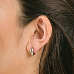 A model wearing the Everyday Essentials Set features three closure types: invisible resin, sliding spring and mosquito coil. It includes a Simple Silver Huggie Clip-On, Mini Hoop Earrings and Silver Cassie Hoop Earrings. Crafted from copper alloy, stainless steel and silver tone metal alloy, this item comes with three pairs and is also available in Gold.