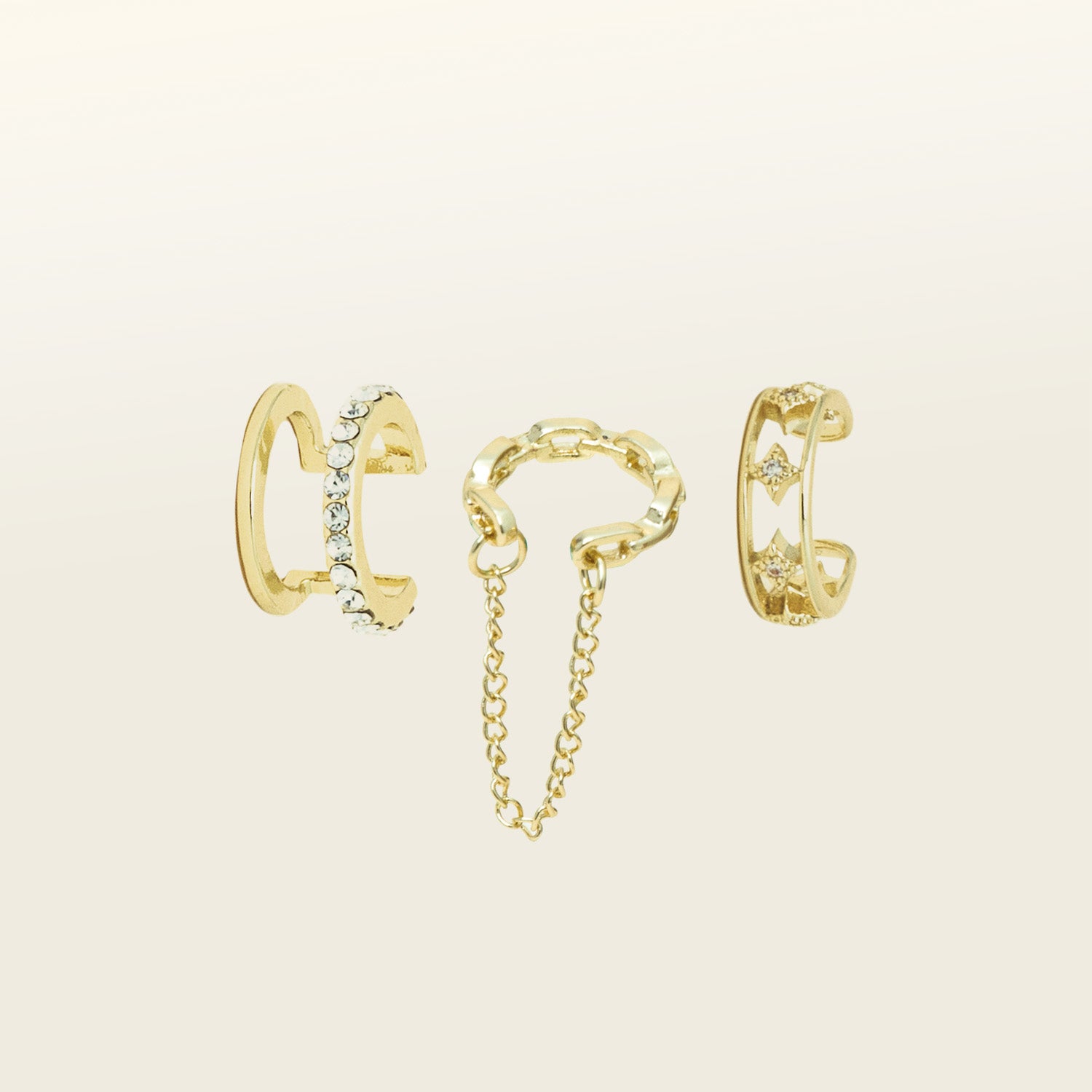 Image of the Ear Cuffs Trio set includes 1pc each of a Dual Chain Ear Cuff, Star Ear Cuff, and Multi Band Ear Cuff. All items come with three pieces. The material composition of the collection is gold plated alloy and cubic zirconia.