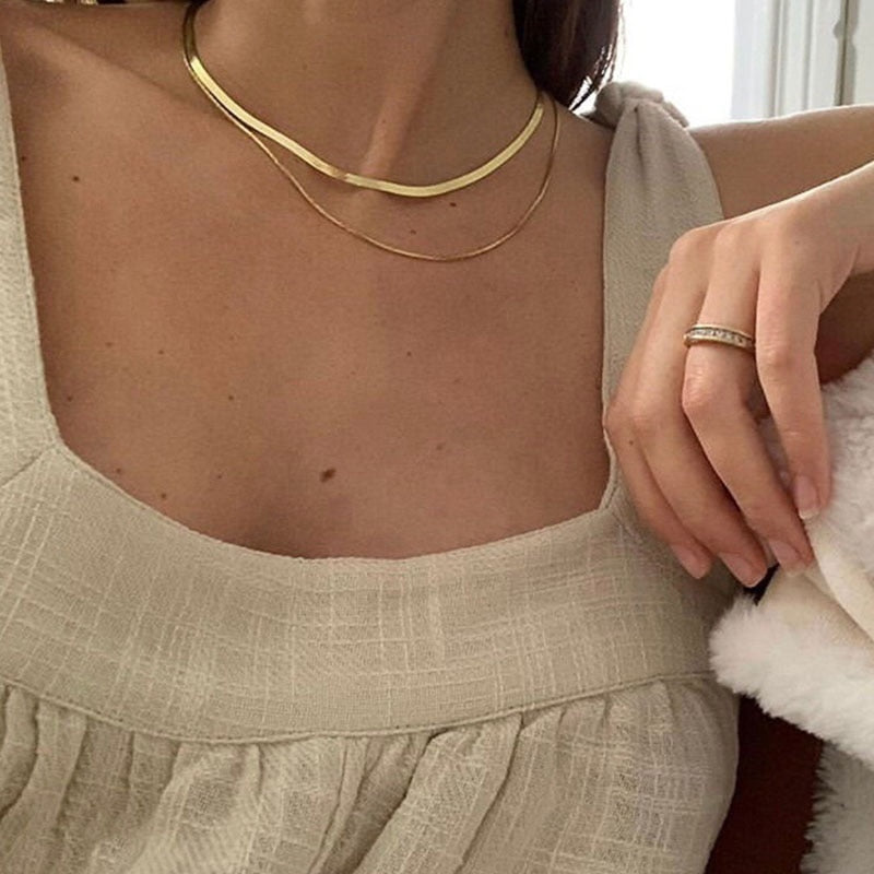 A model wearing the Double Layered Chain Necklace In Gold. This necklace features an adjustable design, and is crafted from 18K Gold Plated Vermeil on Sterling Silver with waterproof and non-tarnish properties. It is also available in Silver.