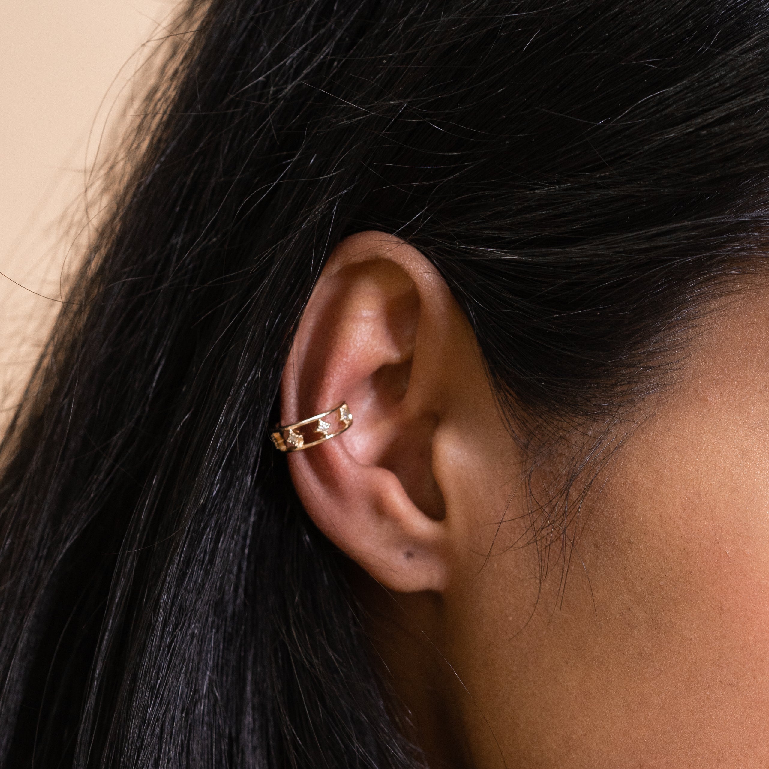 A model wearing our Star Ear Cuff, a sleek and modern accessory crafted from gold-tone plated zinc alloy, adorned with sparkling rhinestones and charming stars. This versatile piece is designed to elevate the style of both women and men, making it the perfect choice to showcase your fashionable side.